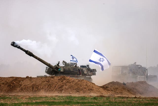 <p>An Israeli army self-propelled artillery howitzer fires rounds from a position near the border with the Gaza Strip in southern Israel</p>