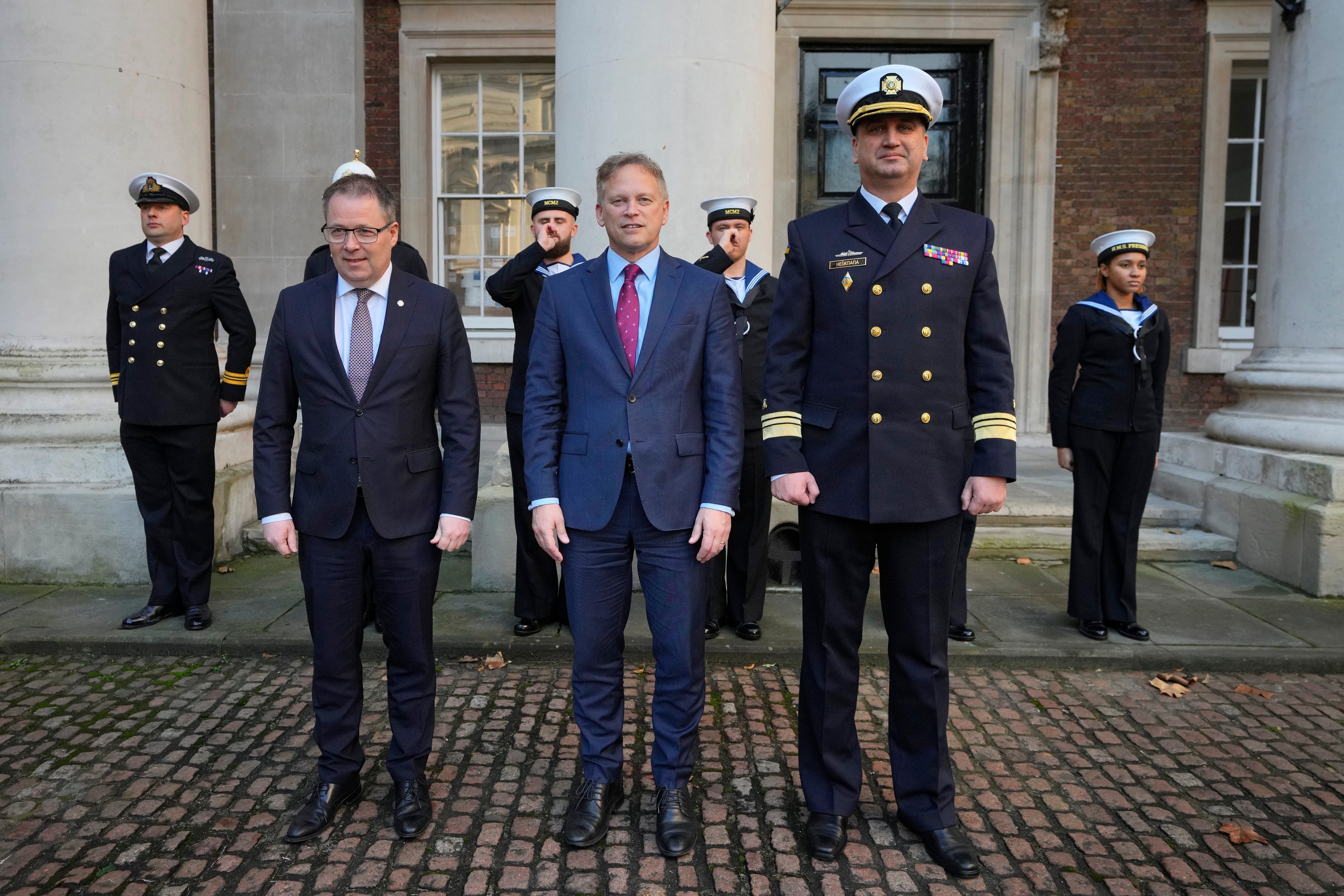 British Defense Secretary Grant Shapps, center, poses with Ukrainian Vice Admiral Oleksii Neizhpapa, right, and Norwegian Defense Minister Bjorn Arild Gram in London in December