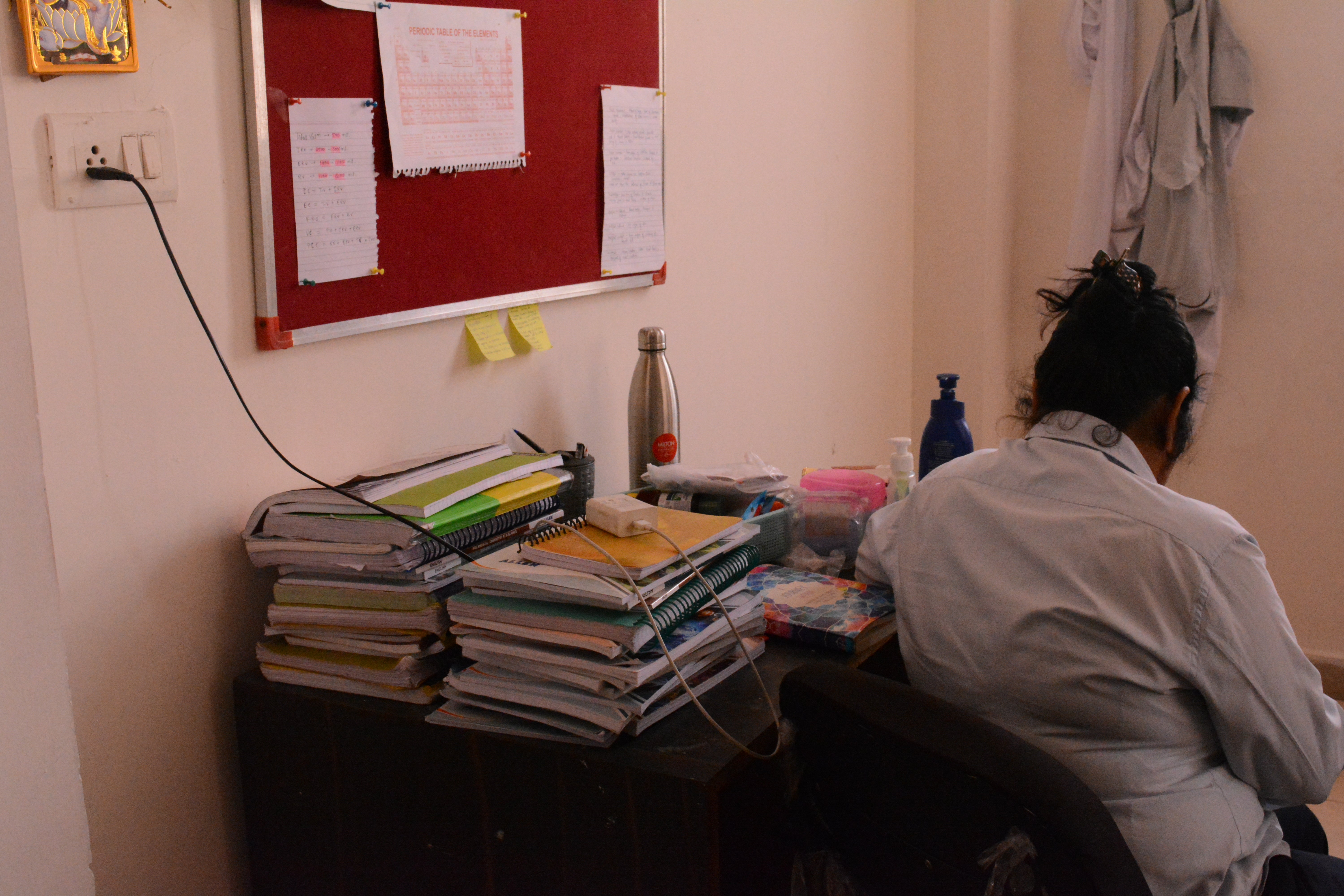 Books for entrance exam preparation stacked on study table of a student in their hostel