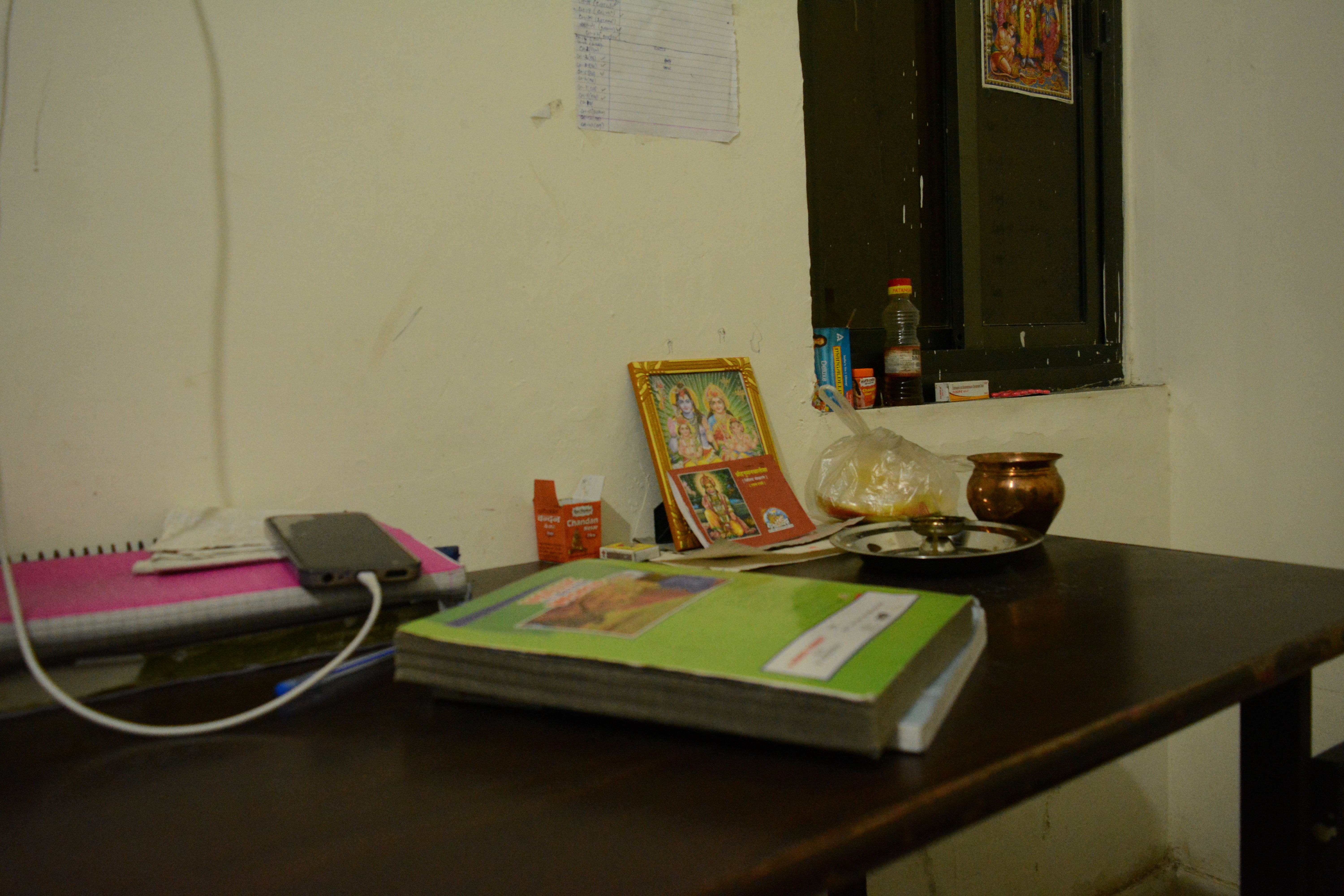 Picture of Hindu gods and goddesses placed on study table in a hostel room in Kota