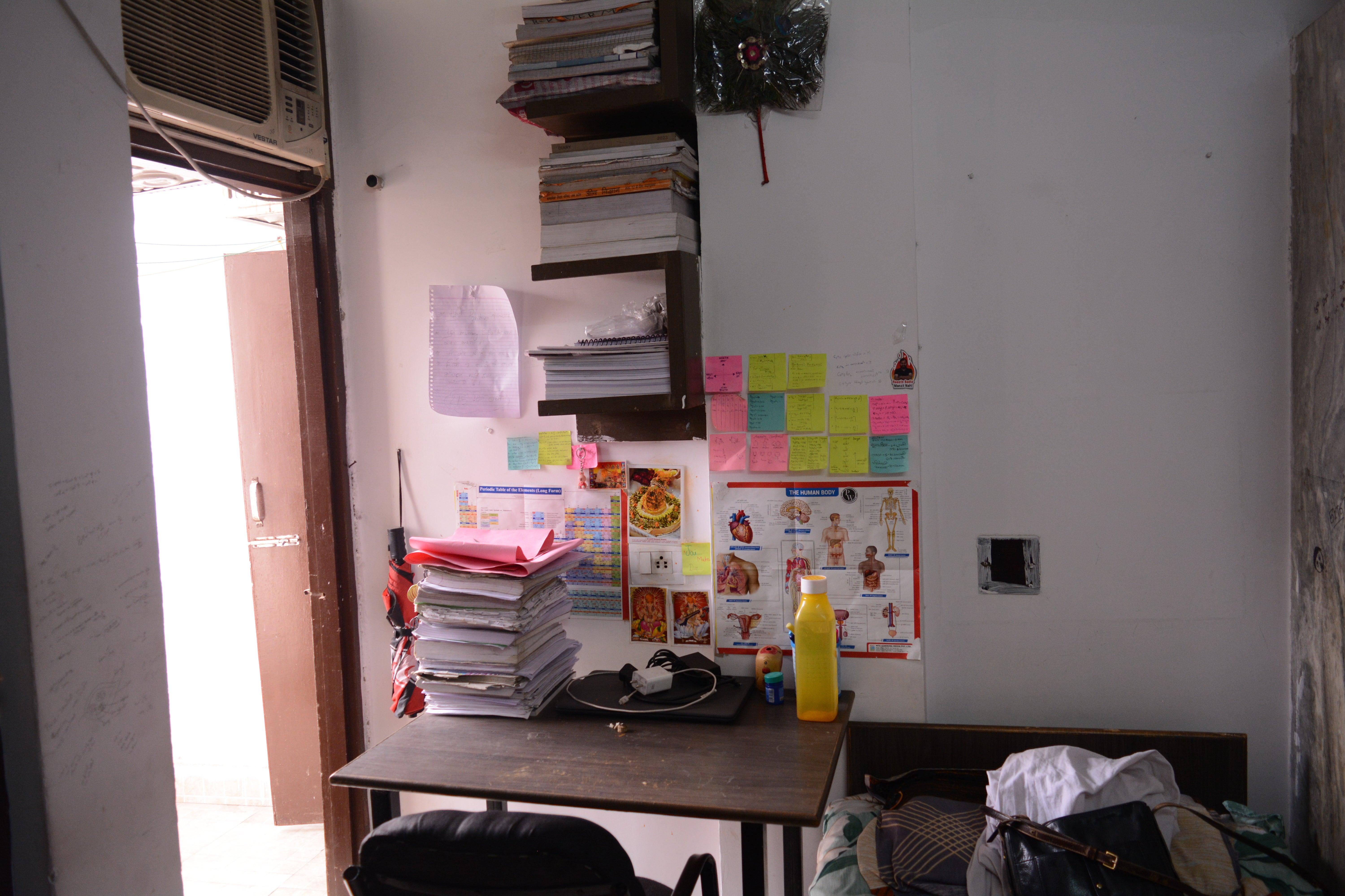 Books stacked on a student’s study table in their hostel room