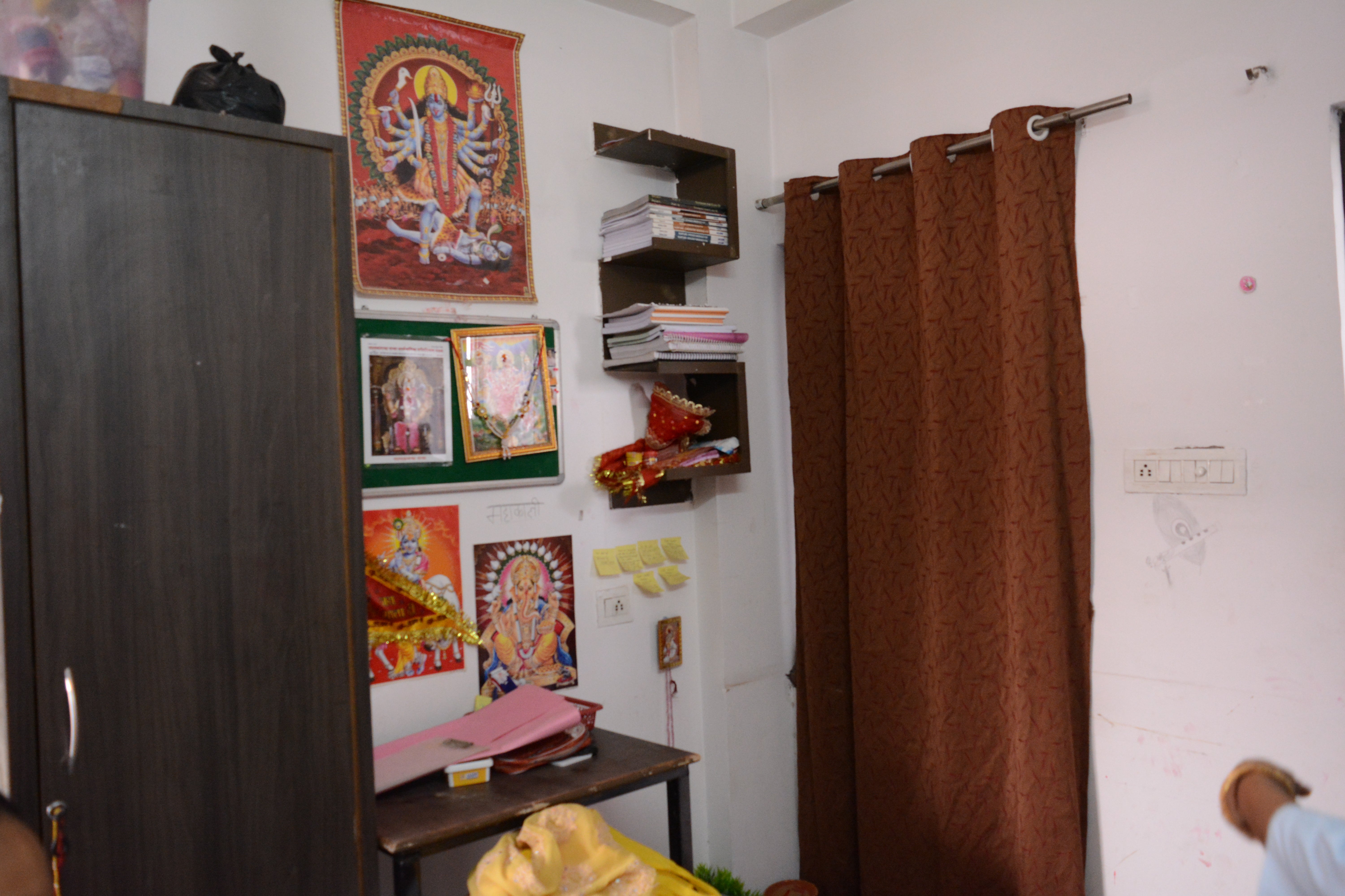Pictures of Hindu gods and goddesses displayed above the study table of a student in Kota