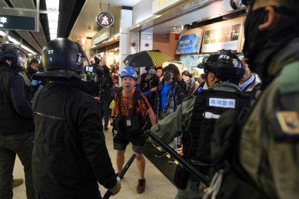A photojournalist (C) argues with police during a protest at the New Town Plaza shopping mall in Shatin in Hong Kong during 2019 protests
