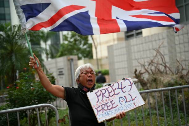 Pro-democracy activist known as Grandma Wong protests outside the court where Hong Kong's largest national security trial against 47 pro-democracy activists started its final argum ents on 29 November, 2023
