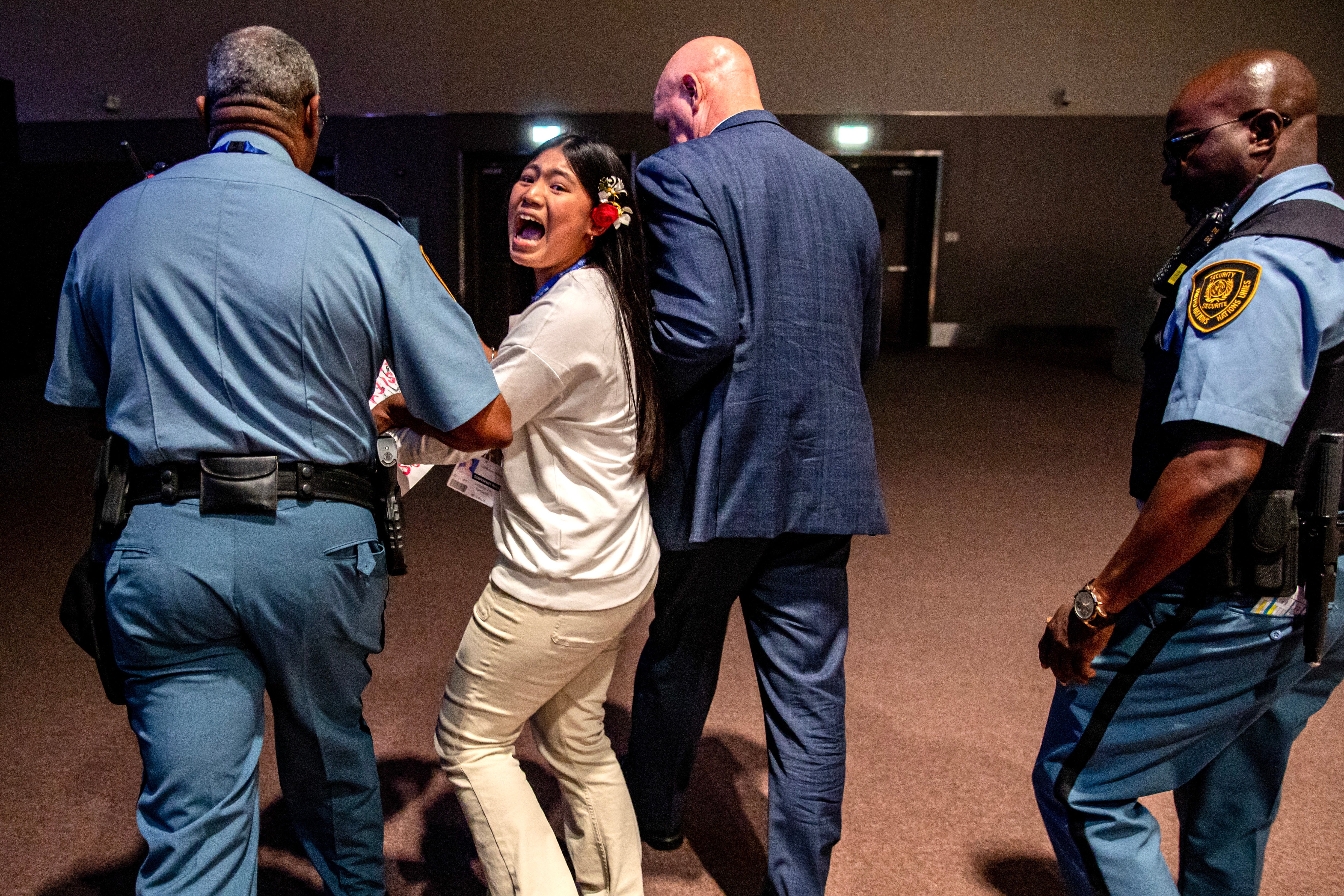Security officers escort indigenous climate activist from India, Licypriya Kangujam,12, as she protests at the 2023 United Nations Climate Change Conference (COP28