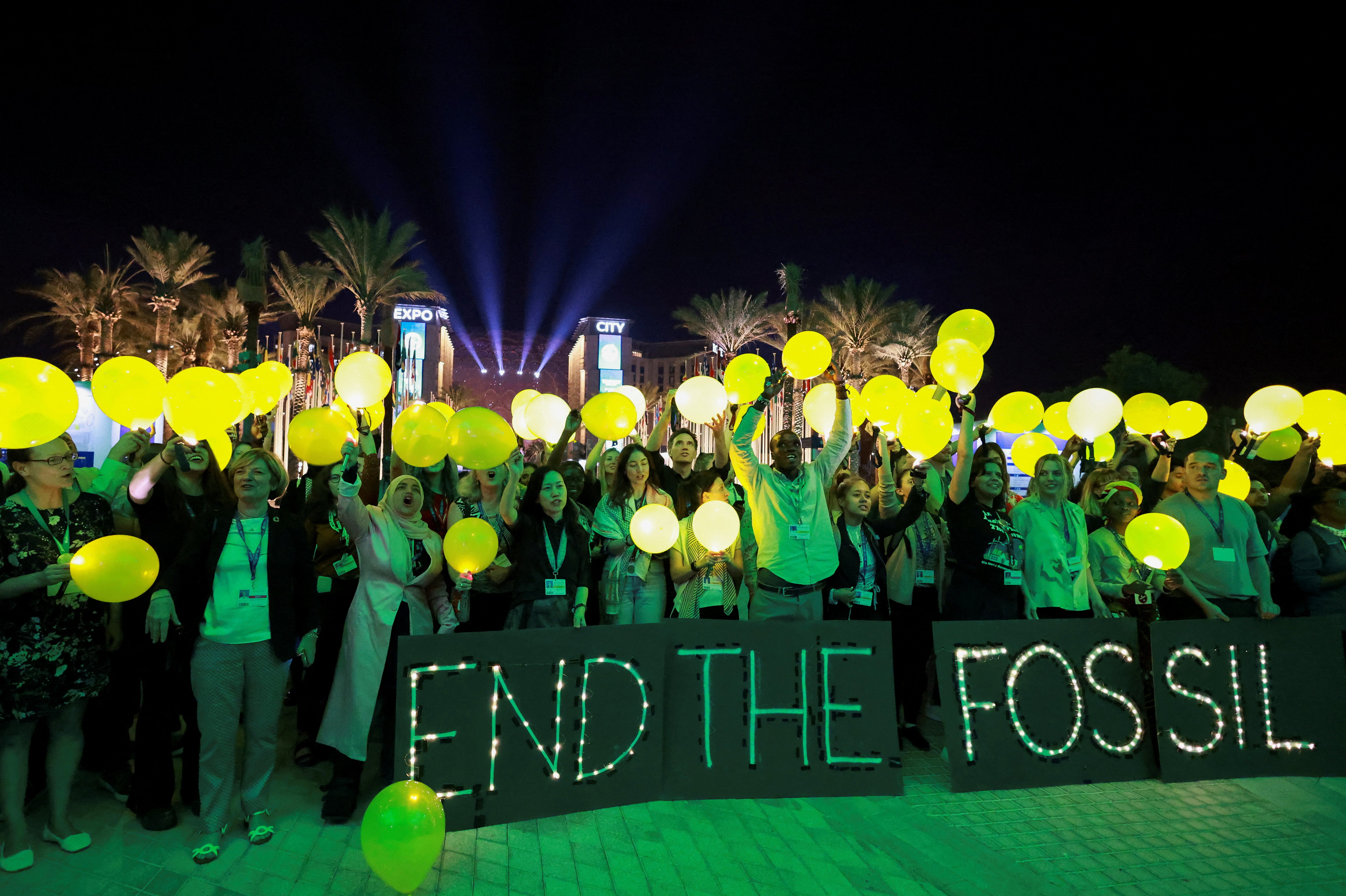 Activists protest on Monday evening inside the Cop28 venue after a draft of the final agreement dropped a call to phase out fossil fuels