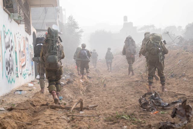 <p>Israeli soldiers march through Gaza during their ongoing fight with the Palestinian group Hamas</p>