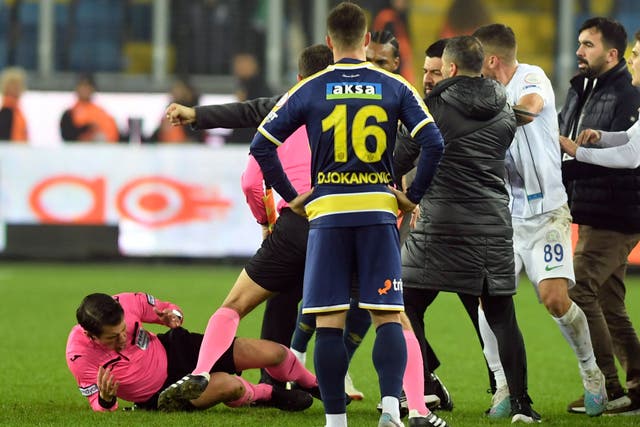 Referee Halil Umut Meler, left, falls to the ground after an attack at the end of the MKE Ankaragucu v Caykur Rizespor match in the Turkish Super Lig on Monday (Abdurrahman Antakyali/AP)