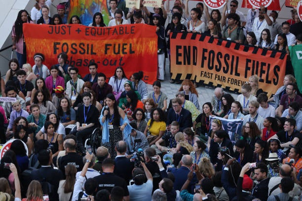 Climate activists protest inside the Dubai Expo venue to demand a phase-out of fossil fuels