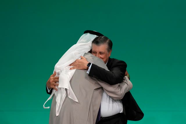 <p>Cop28 president Sultan al-Jaber, left, embraces Cop28 CEO Adnan Amin</p>