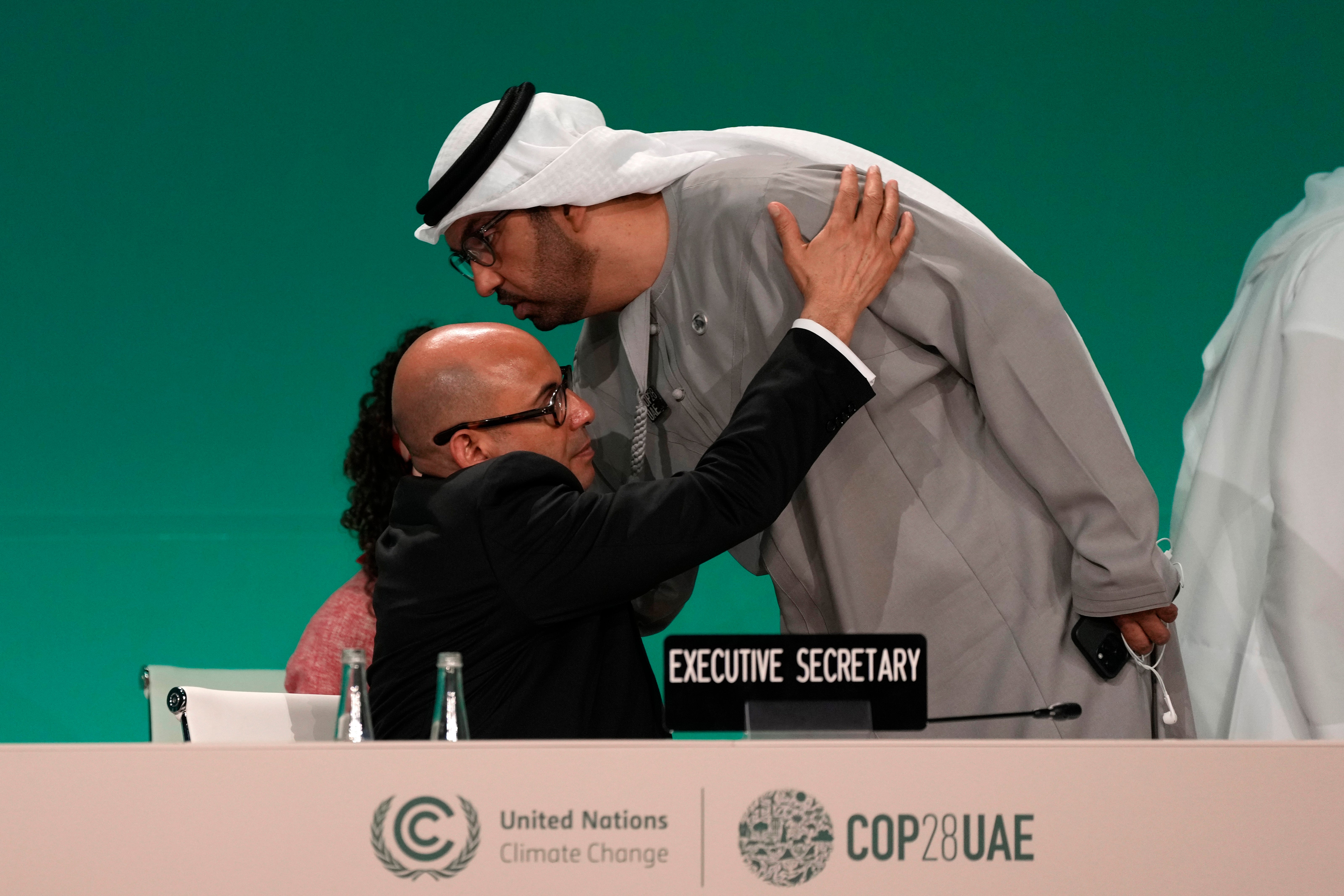 United Nations Climate Chief Simon Stiell embraces COP28 President Sultan al-Jaber as he returns to a plenary session at Cop28