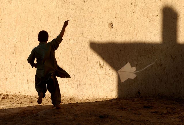 <p>A young Afghan boy flies a kite November 12, 2001 in a Afghan refugee district of Quetta, Pakistan.</p>