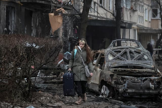 <p>Residents leave their apartment building damaged during a Russian missile strike in Kyiv</p>