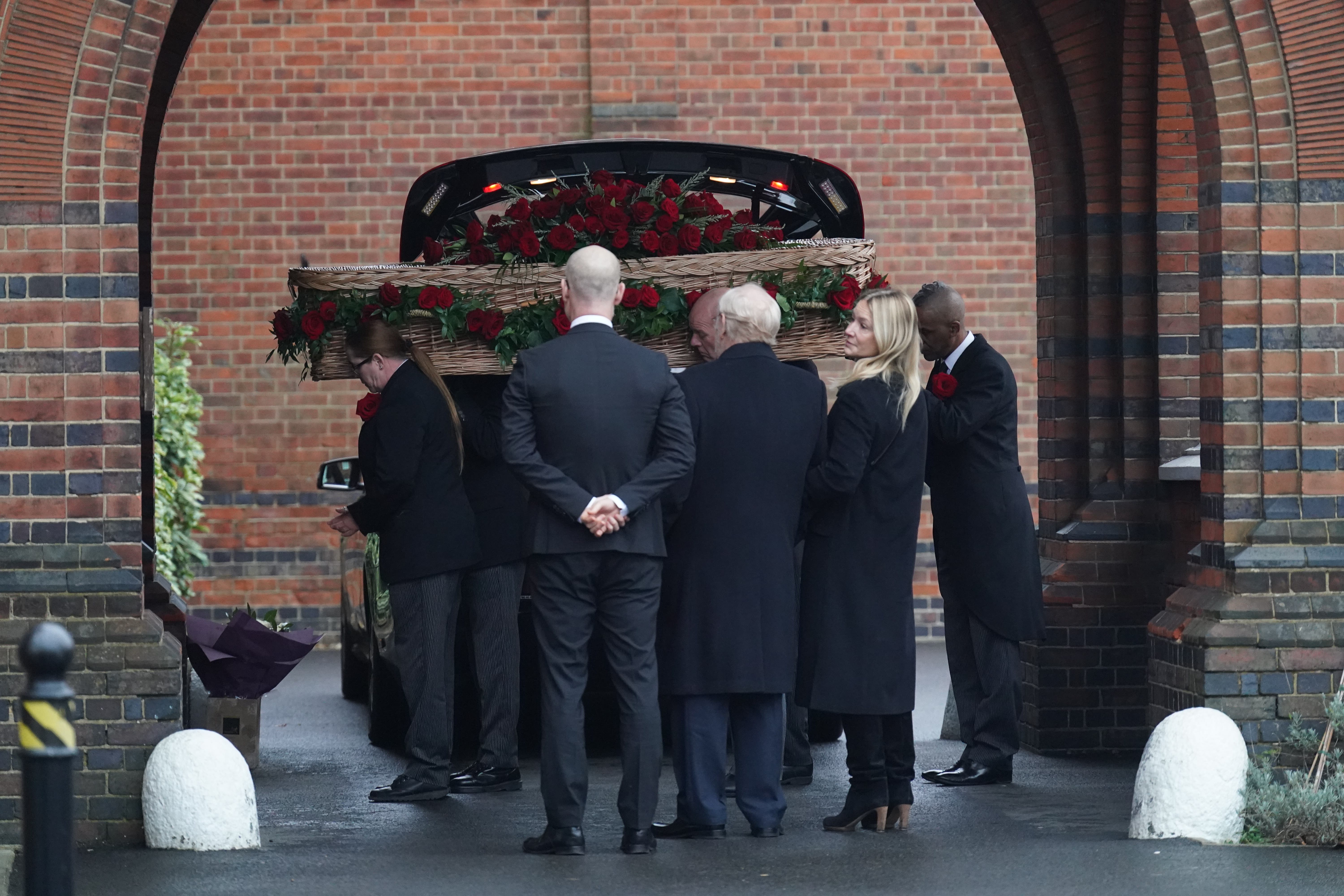Stephen Kinnock, Lord Neil Kinnock and Rachel Kinnock watch as the coffin is carried into Golders Green Crematorium (Stefan Rousseau/PA)