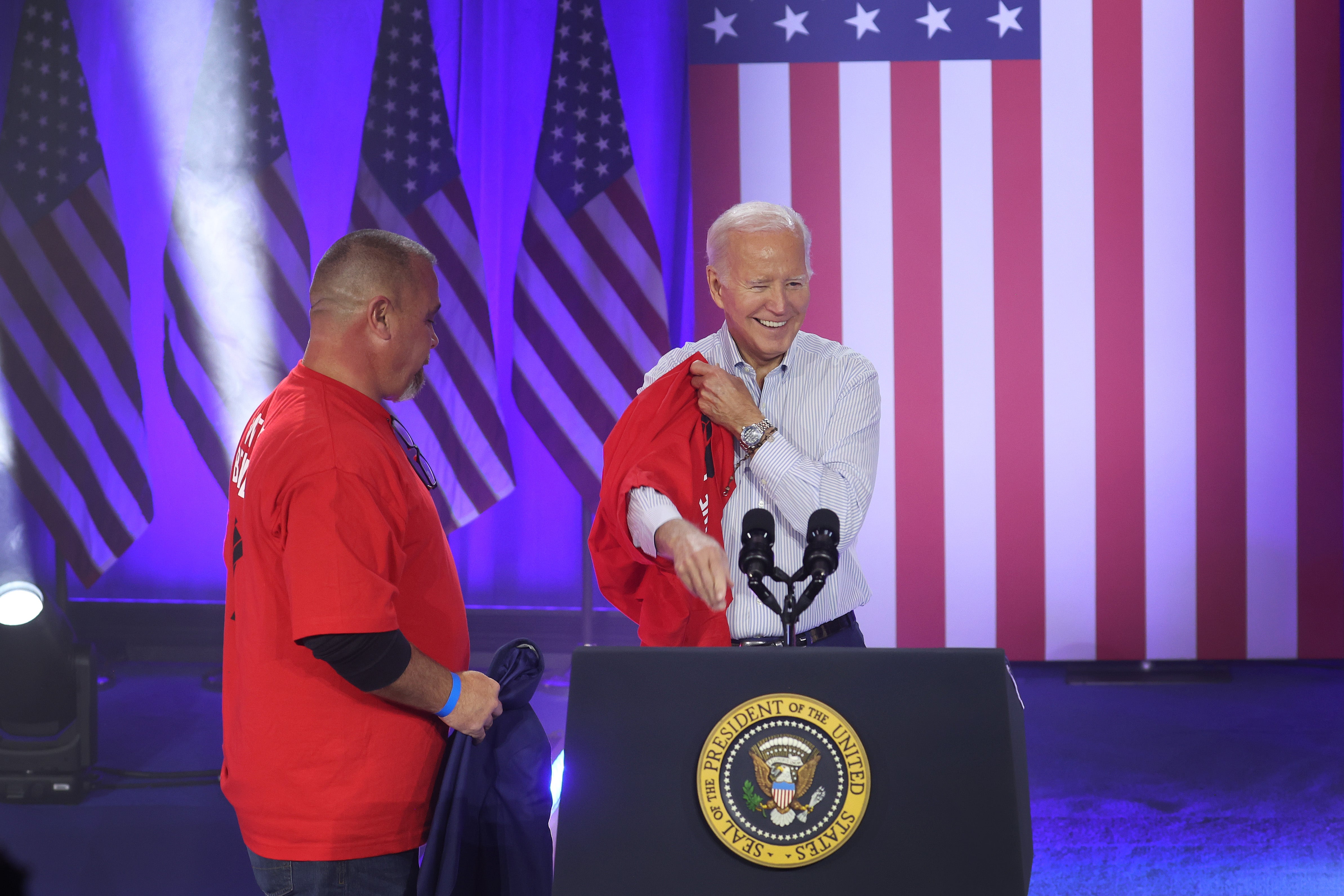 President Joe Biden puts on a United Auto Workers shirt before speaking to autoworkers at the Community Complex Building in Belvidere, Illinois in November