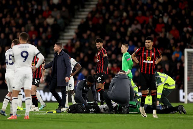 <p>Luton defender Tom Lockyer received treatment on the pitch before the game was eventually called off (Steven Paston/PA)</p>