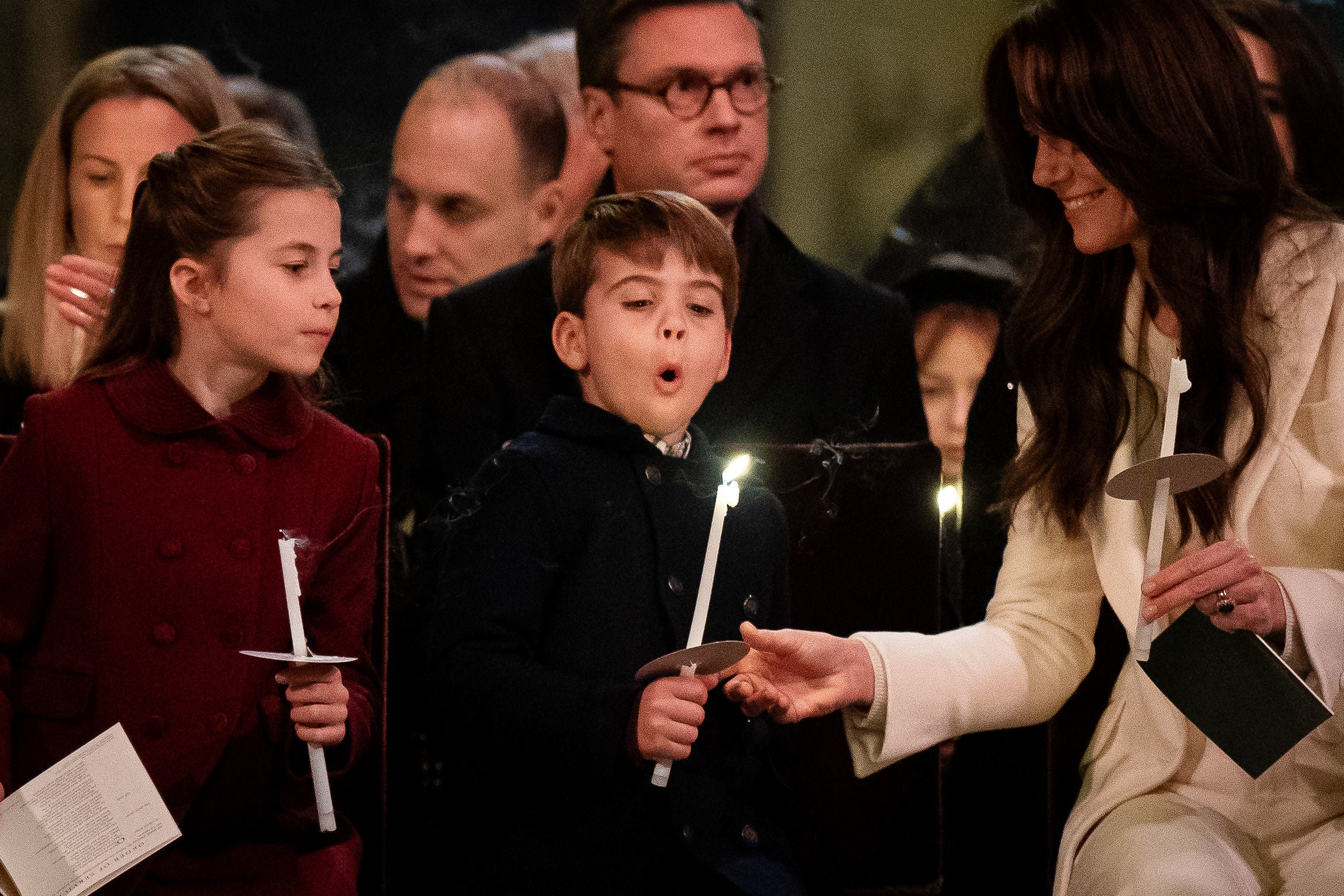 Prince Louis attempts to blow out his candle as the Princess of Wales watches on