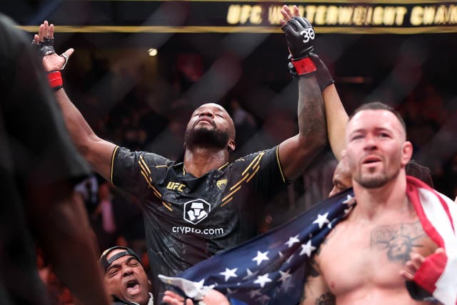 <p>Leon Edwards (centre) celebrates his victory over Colby Covington (right)</p>