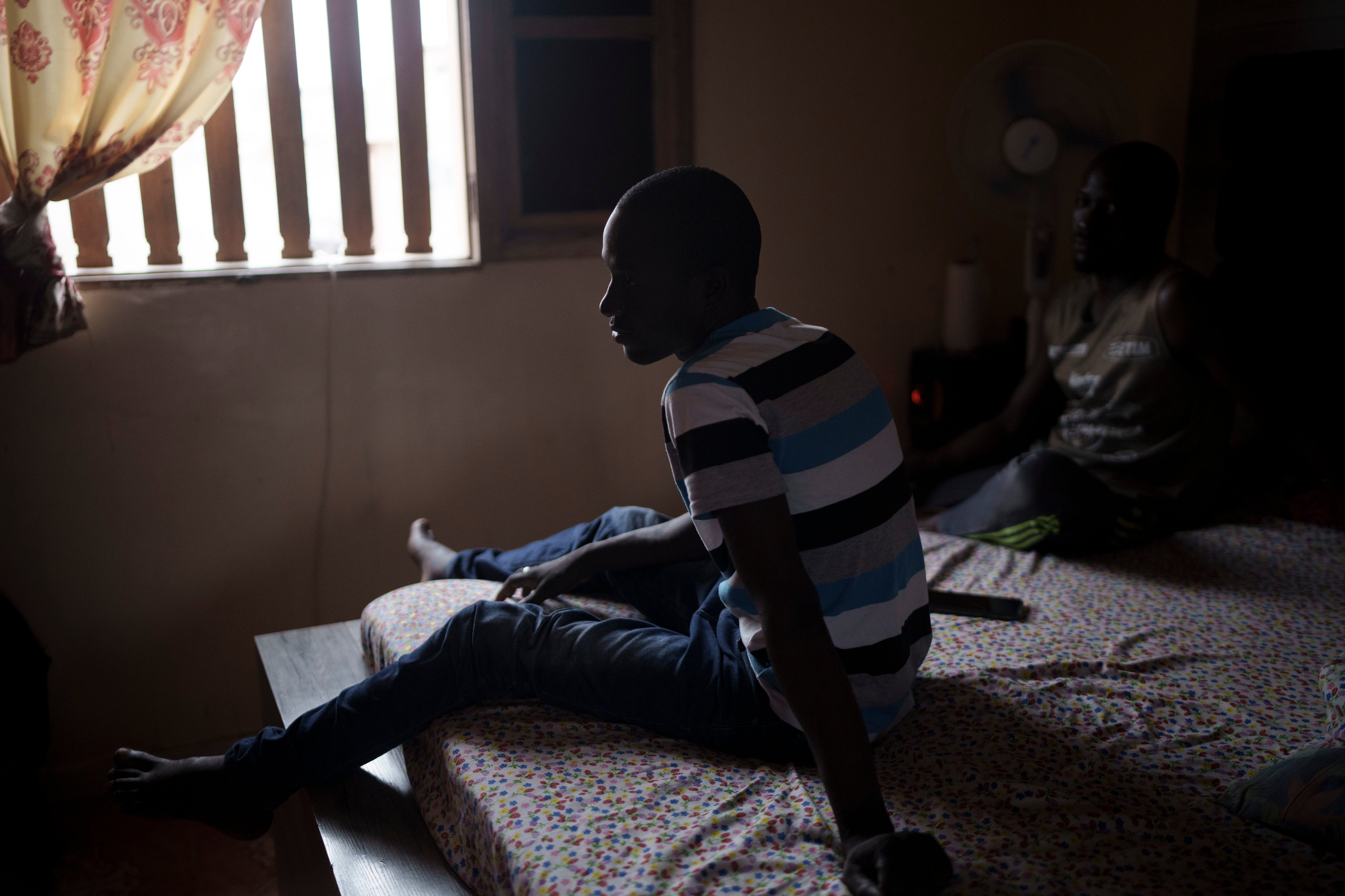 Moustafa Diallo, 28, rests on a bed at a friend's home in Diogo Sur Mer, Senegal, Monday, Aug. 28, 2023. (AP Photo/Felipe Dana)