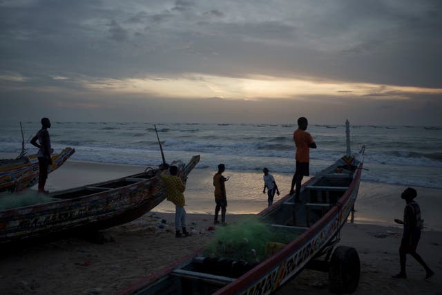 <p>Senegalese youth gather around pirogues on the beach at dusk in Fass Boye, Senegal, Tuesday, Aug. 29, 2023. </p>