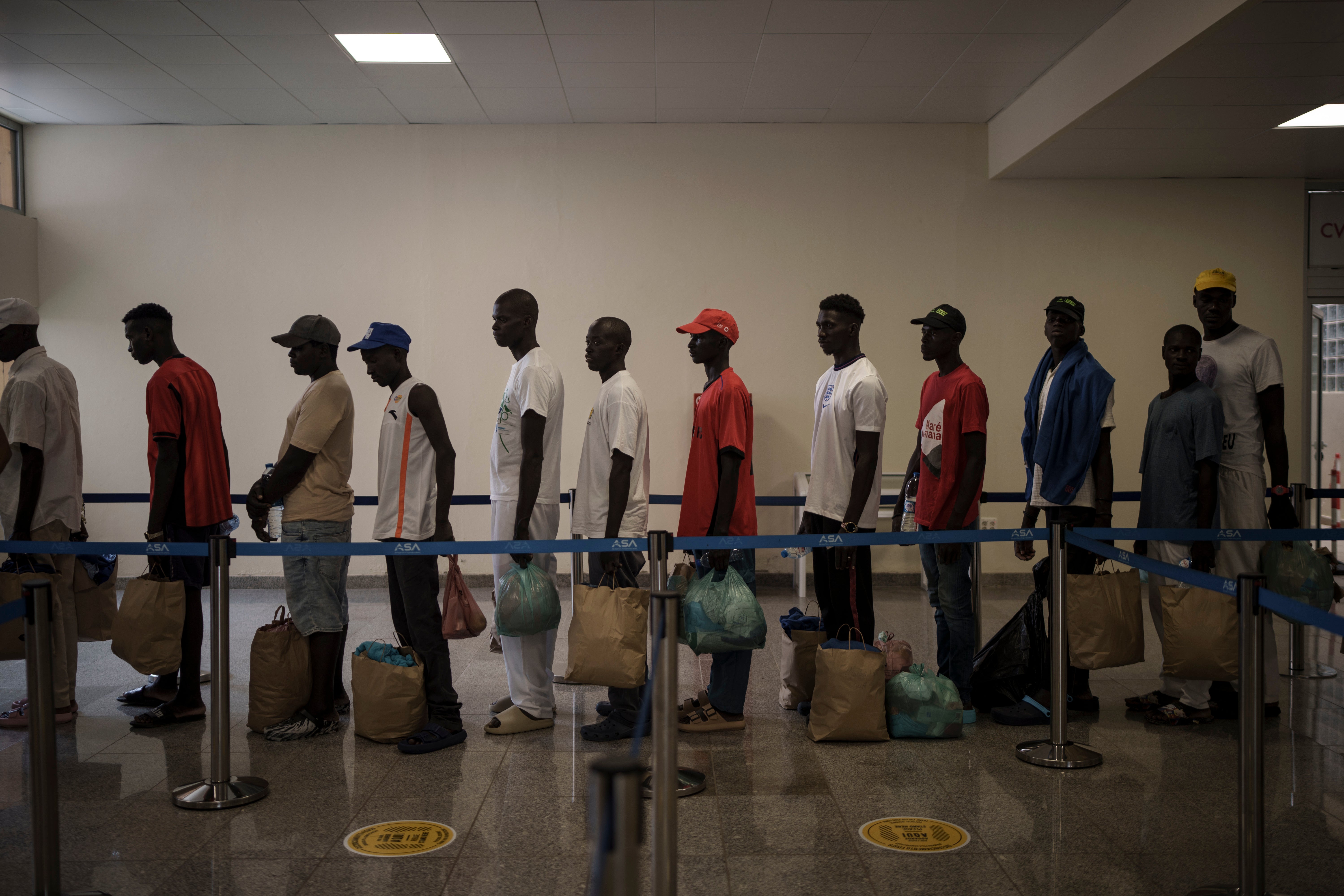 Survivors of the Senegalese pirogue that was found adrift, queue at the airport before boarding a government repatriation flight on the island of Sal, Cape Verde, Monday, Aug. 21, 2023
