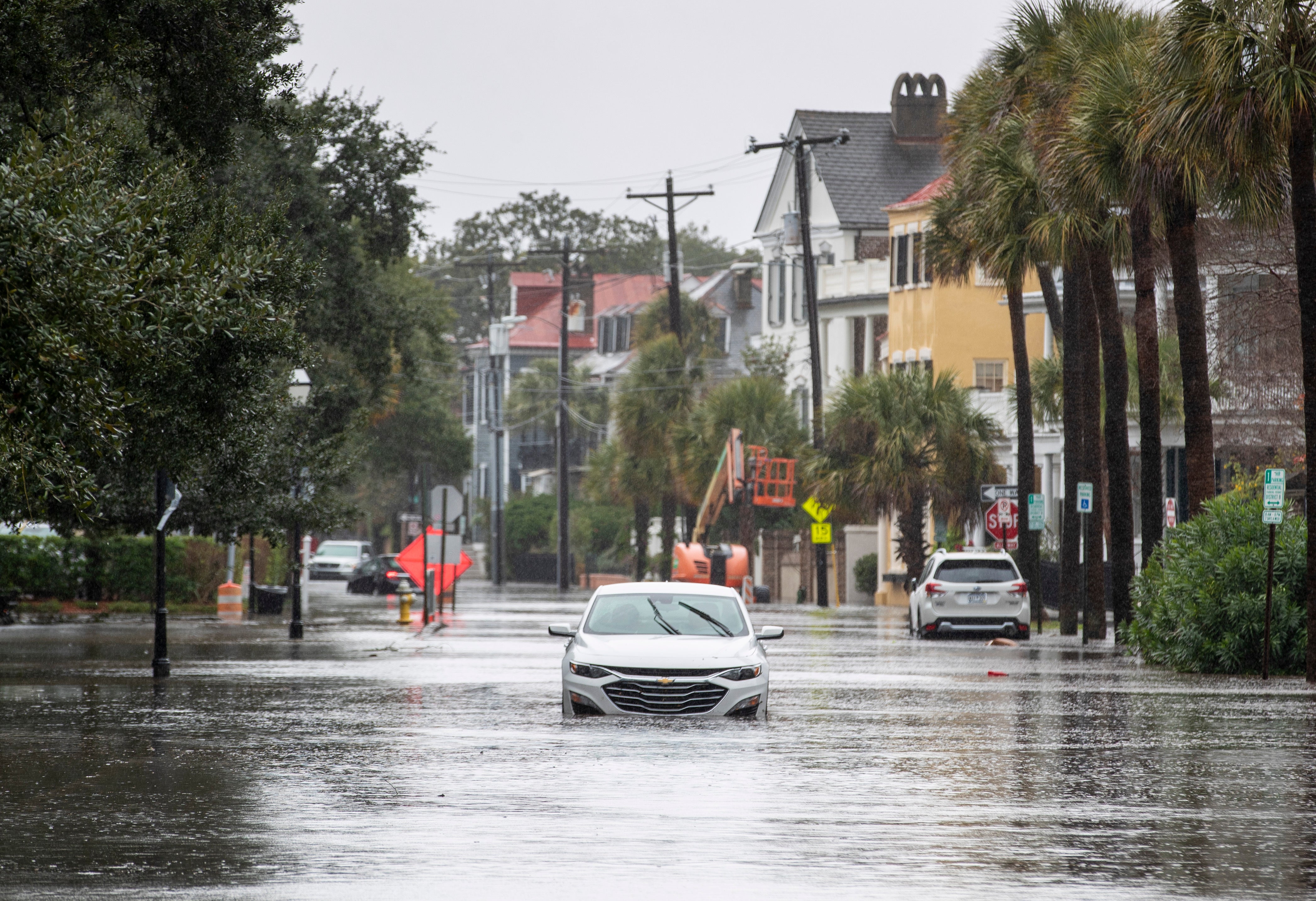 A car drives through a flooded street near the Battery on Sunday
