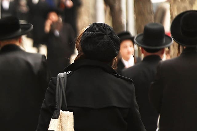 <p>Hasidic men and women walk through a Jewish Orthodox neighborhood in Brooklyn on April 24, 2017 in New York City.</p>