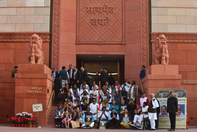 <p>Indian lawmakers sit on the stairs of the parliament building in protest against the suspension of lawmakers, in New Delhi, India, Tuesday, 19 December 2023</p>