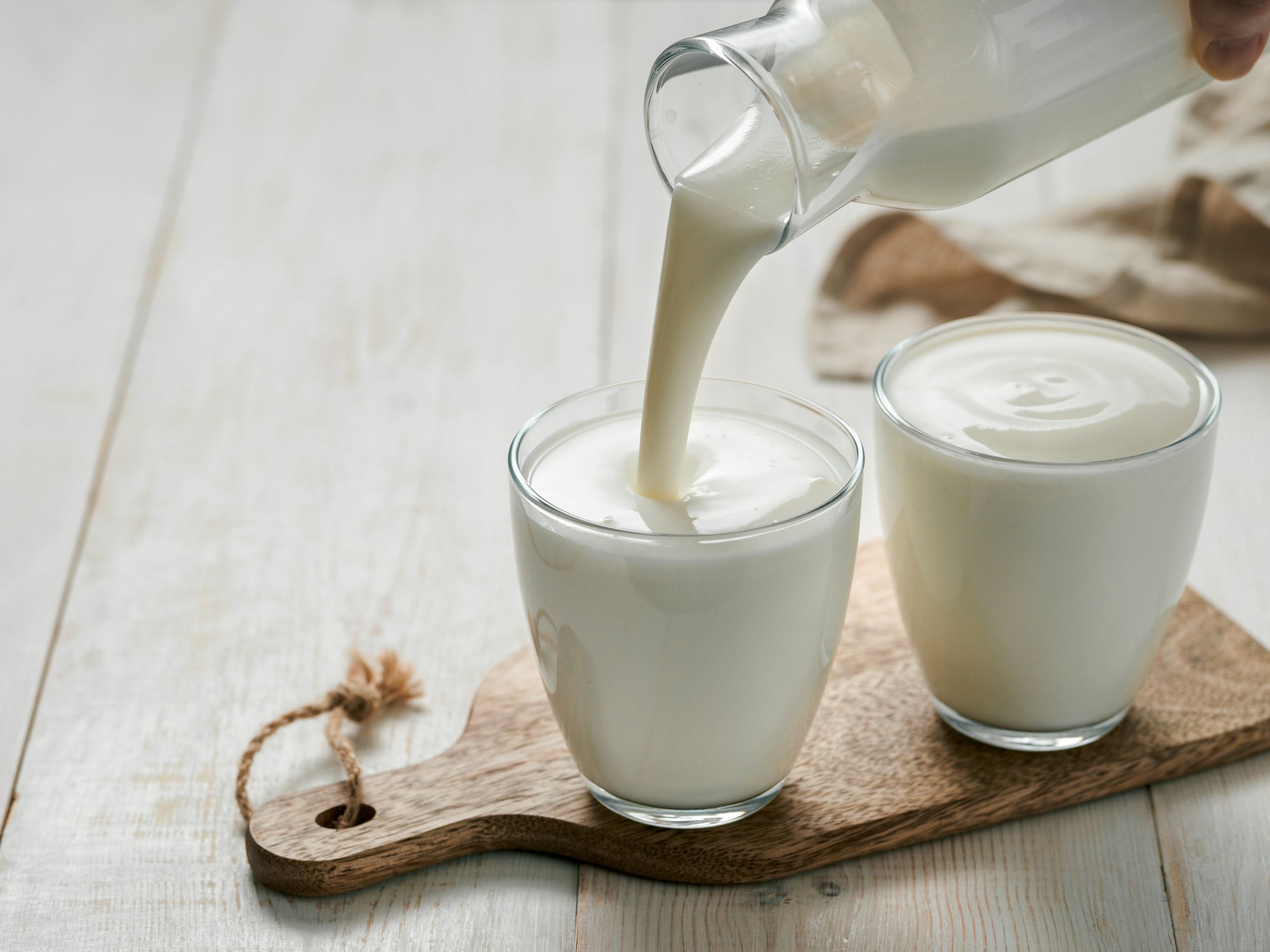 Pouring homemade kefir, buttermilk or yogurt with probiotics