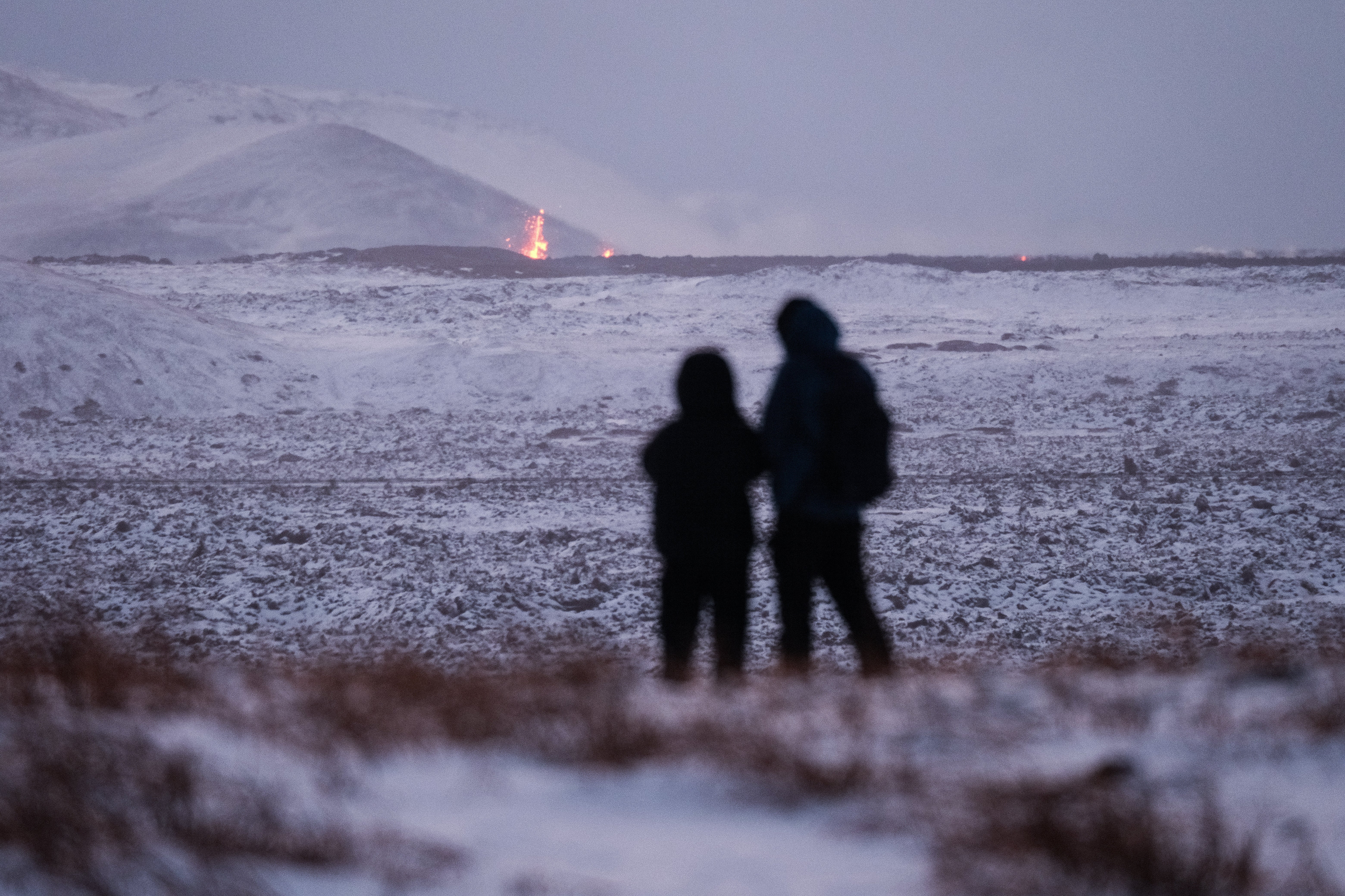 Onlookers gather to watch the lava flow after the eruption on the Reykjanes Peninsula