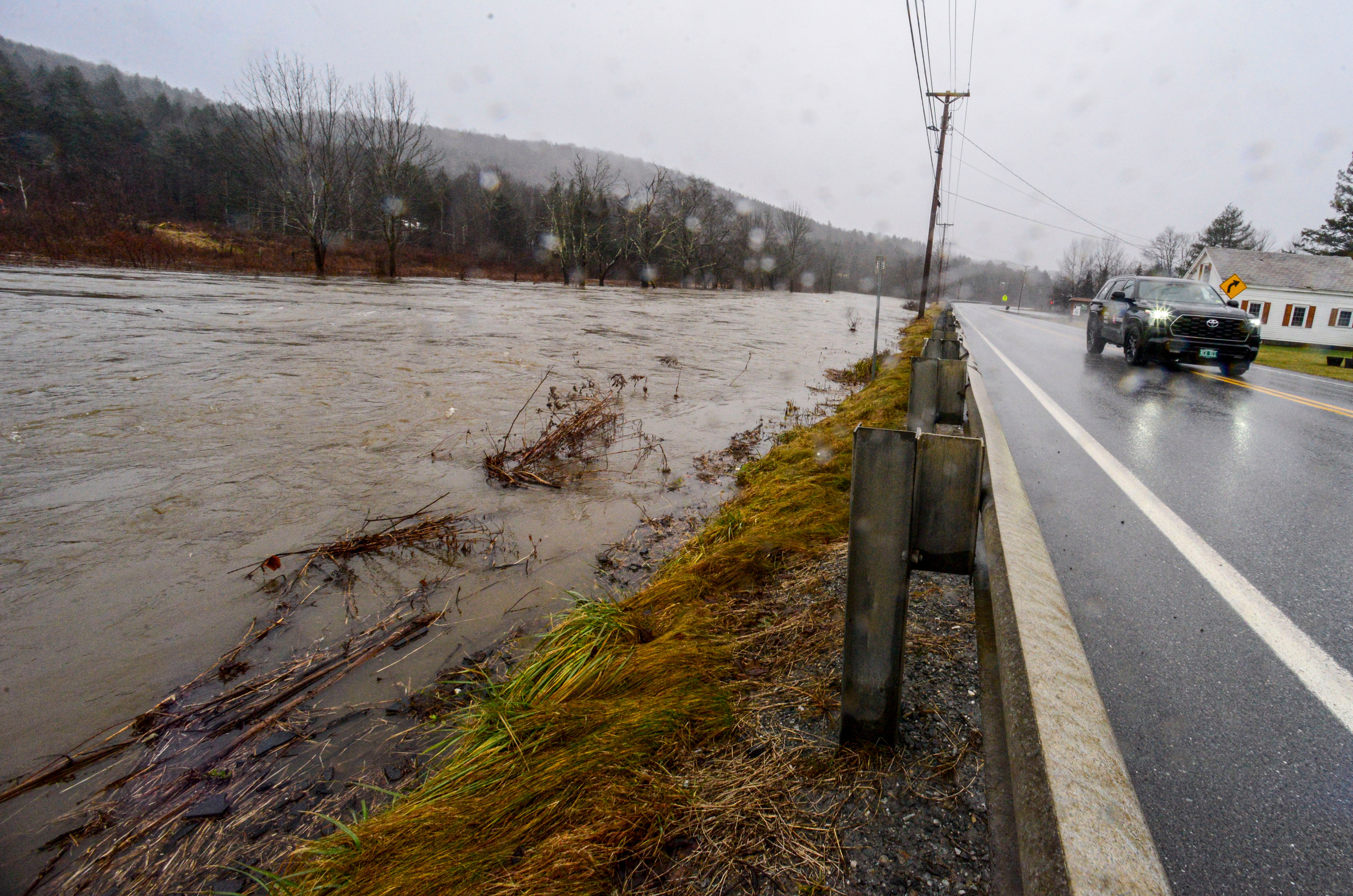 The water level of the Deerfield River creeps up to the edge of Route 100 in Wilmington