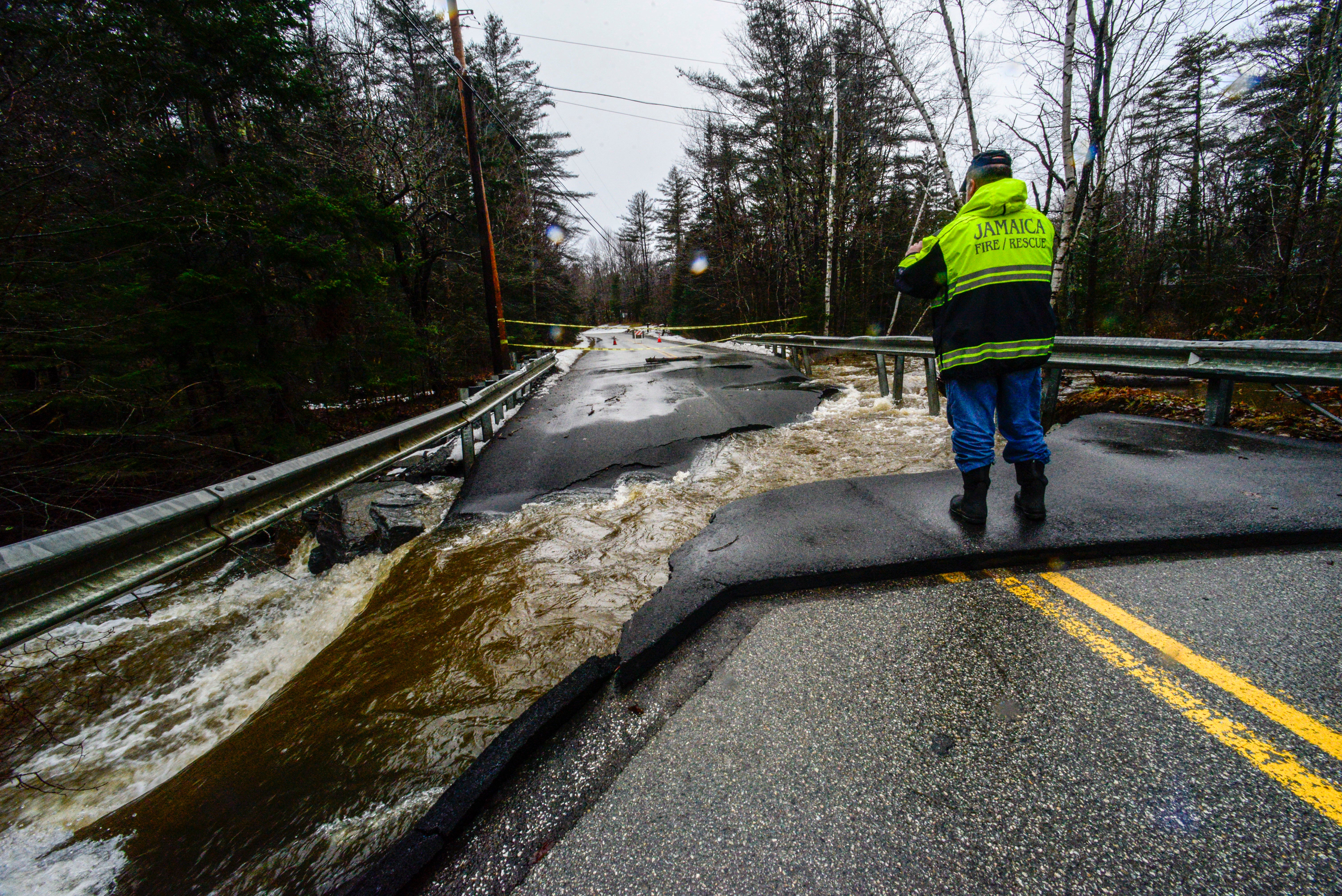 Members of the Jamaica, Vt., Fire Department look at the damage to a failed culvert for the North Branch Ball Mountain Brook on Monday