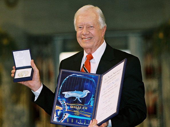 Former president Jimmy Carter holds up his Nobel Peace Prize December 10, 2002 in Oslo, Norway. His granson said he is no longer awake every day while in hospice care.