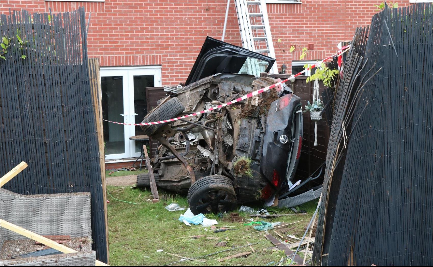 The car came to a stop on its side in a residential garden