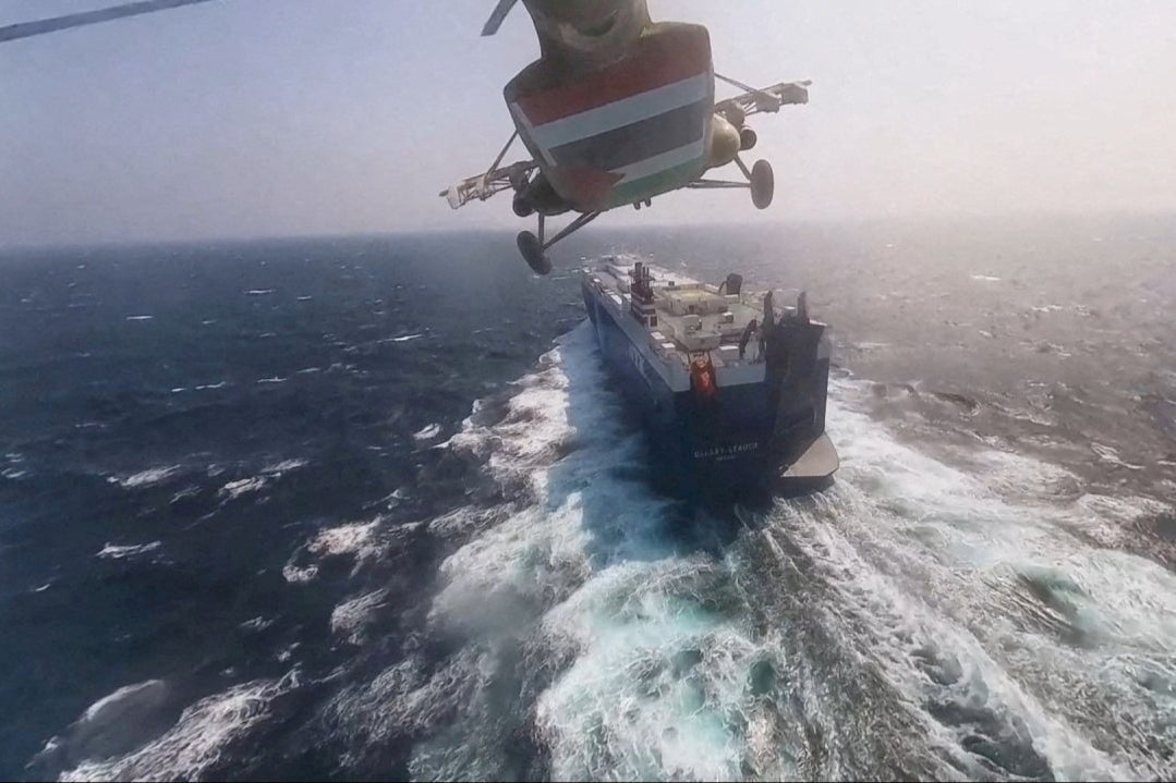 Houthi military helicopter flies over the Galaxy Leader cargo ship in the Red Sea