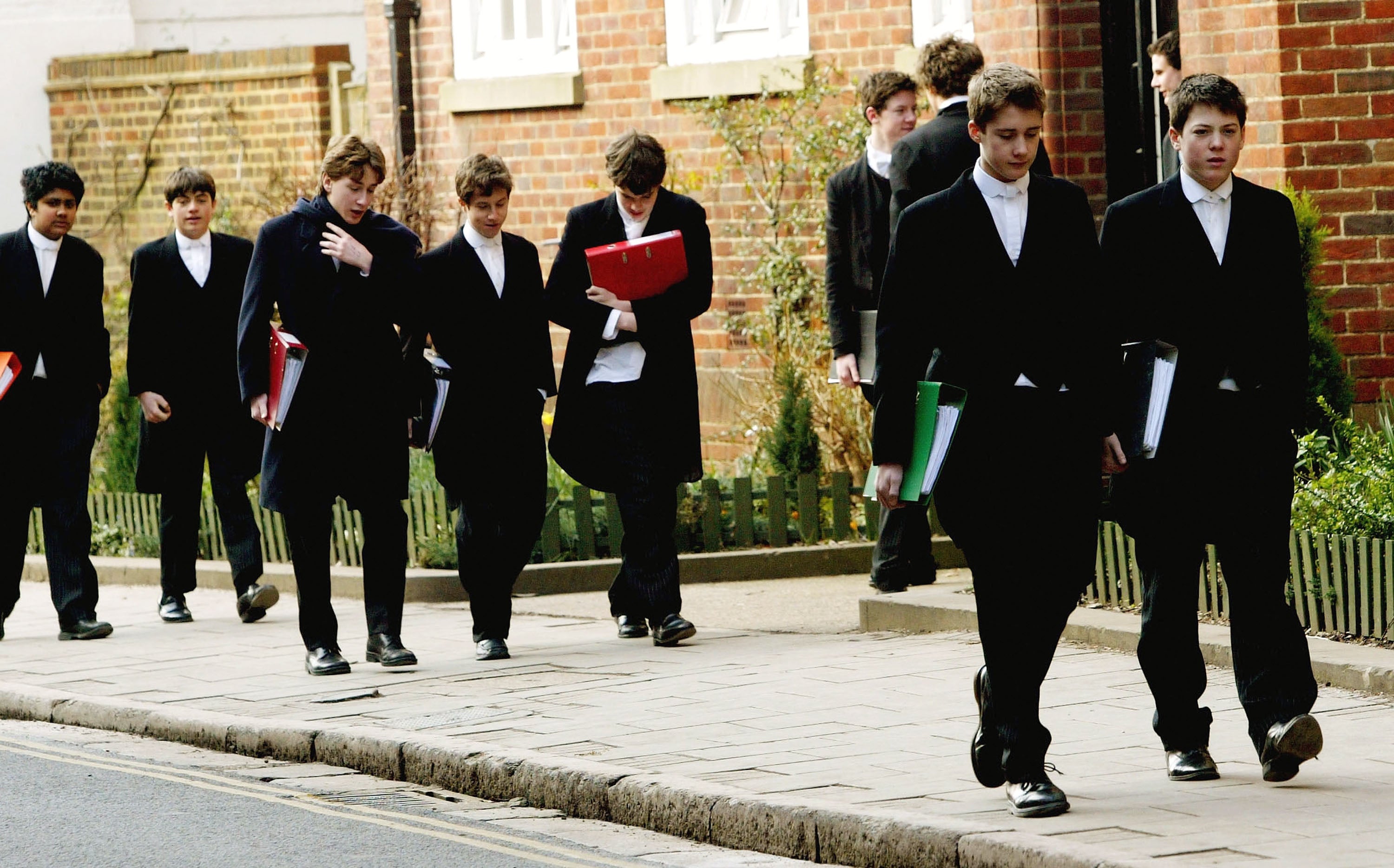 Tailcoated pupils at Eton College hurry between lesson