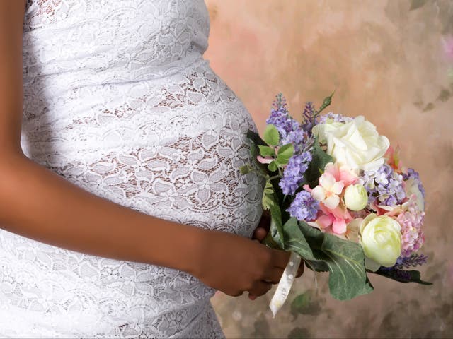 <p>Pregnant bride with a bouquet of flowers in hand / iStock</p>