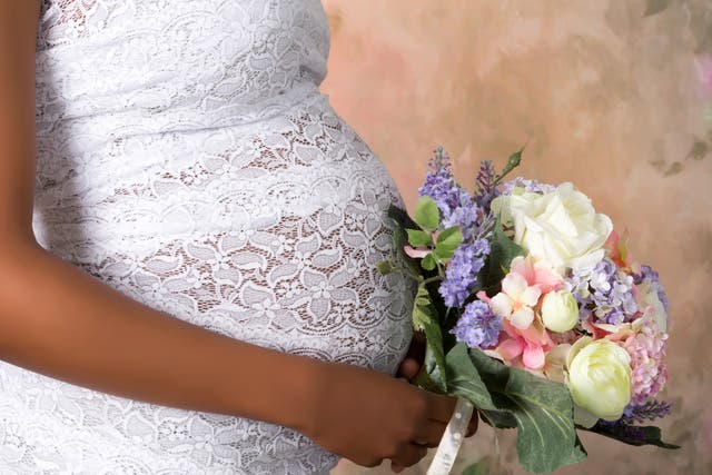 <p>Pregnant bride with a bouquet of flowers in hand / iStock</p>