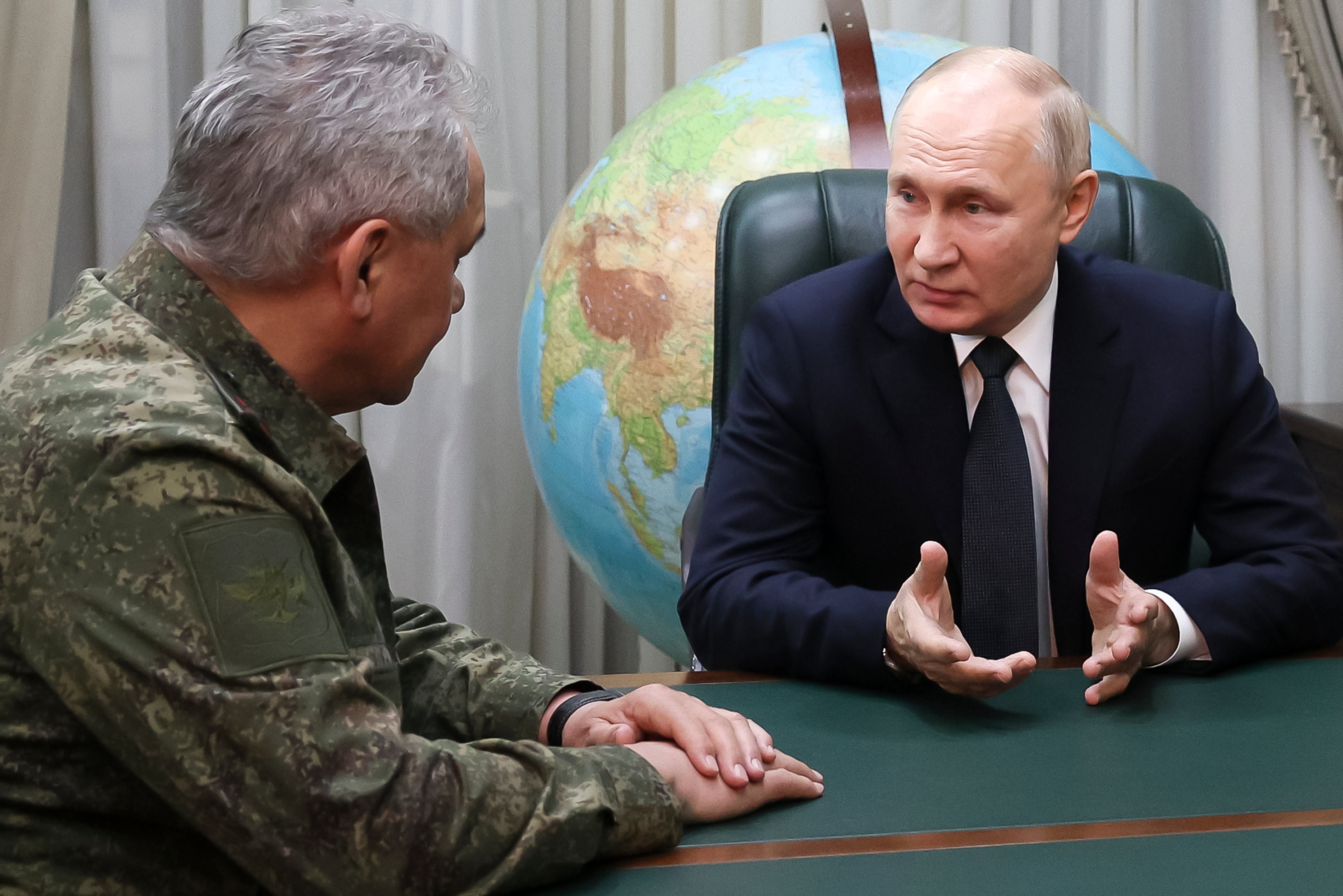 Russian president Vladimir Putin sits with defense minister Sergei Shoigu. Russia raised the maximum age of conscription from 27 to 30