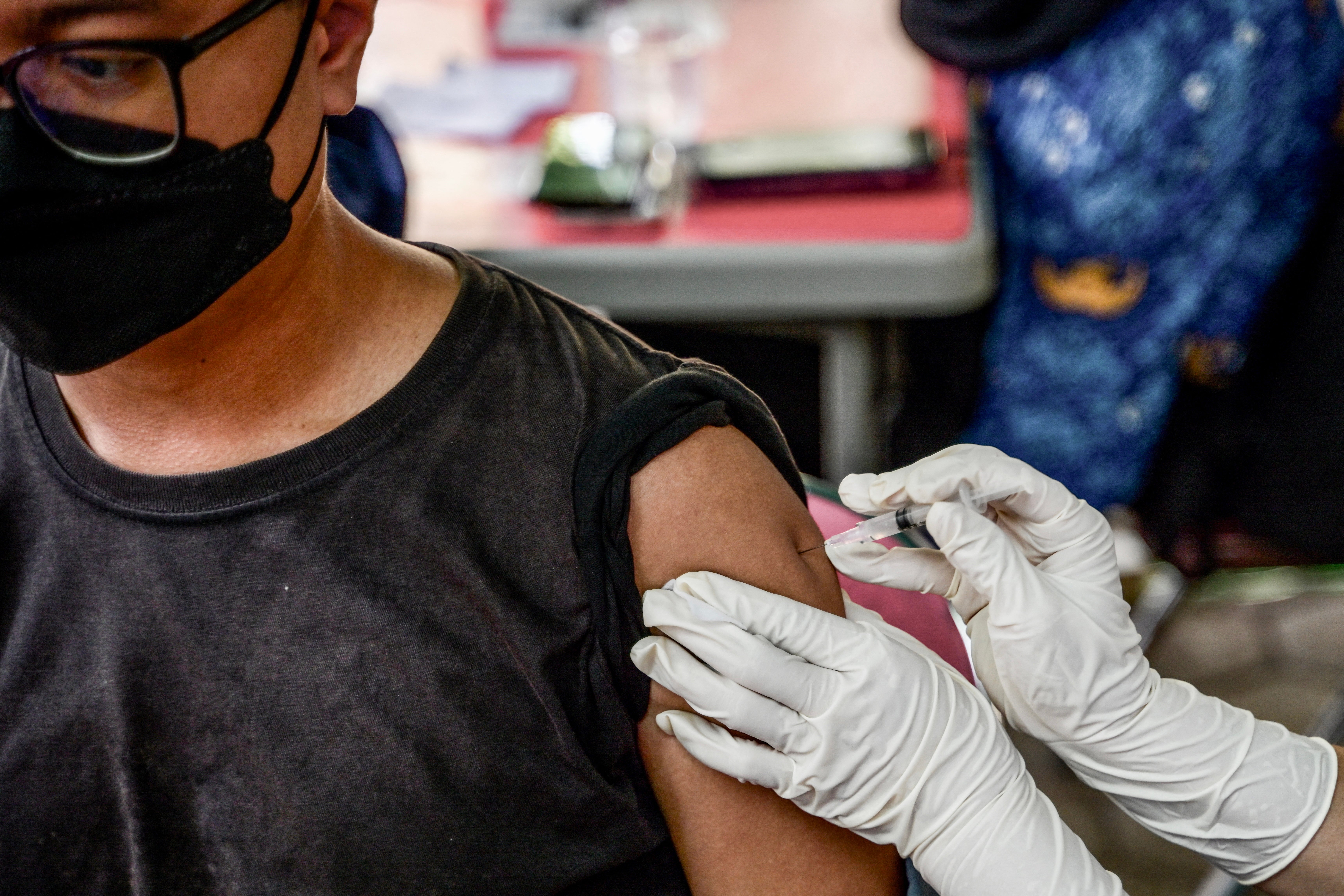 A patient receives the updated COVID-19 vaccine, which infectious disease experts say is crucial for protection against the JN.1 subvariant