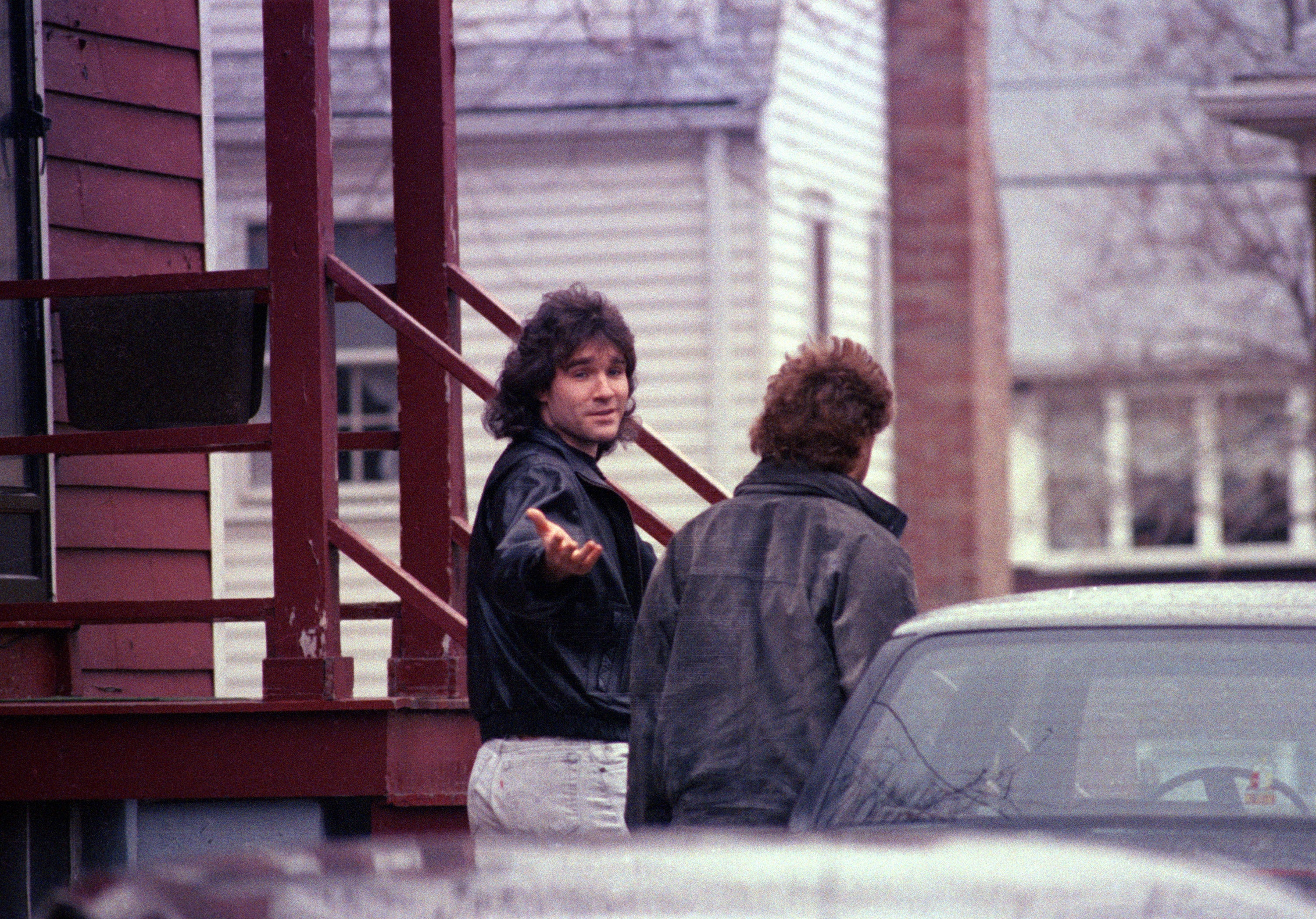 Matthew Stuart, brother of Charles Stuart, gestures toward members of the media outside his family's home in Revere, Mass., Jan. 10, 1990