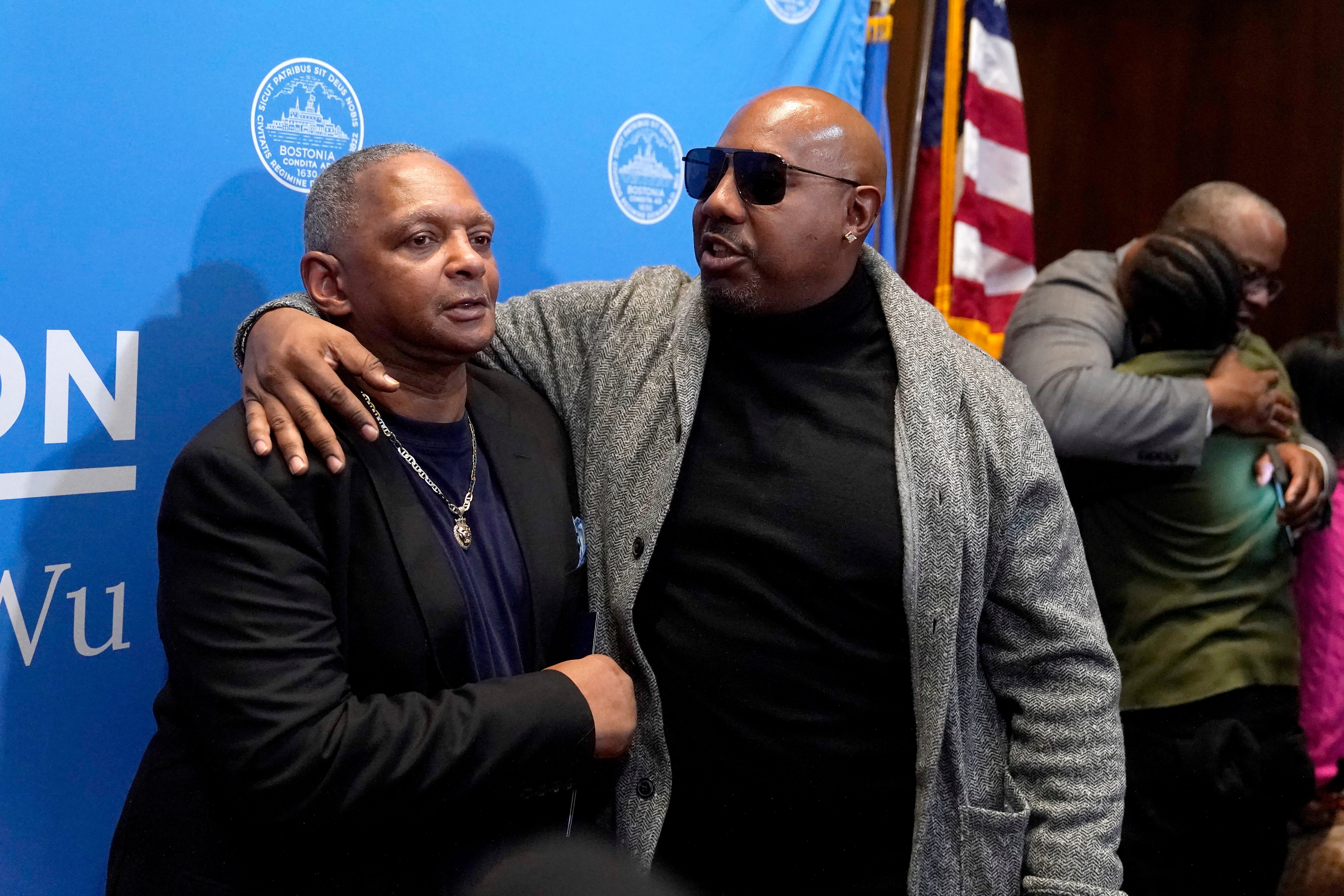Alan Swanson, left, is embraced by Joseph Bennett, nephew of Willie Bennett, center, following a news conference Wednesday, Dec. 20, 2023, in Boston