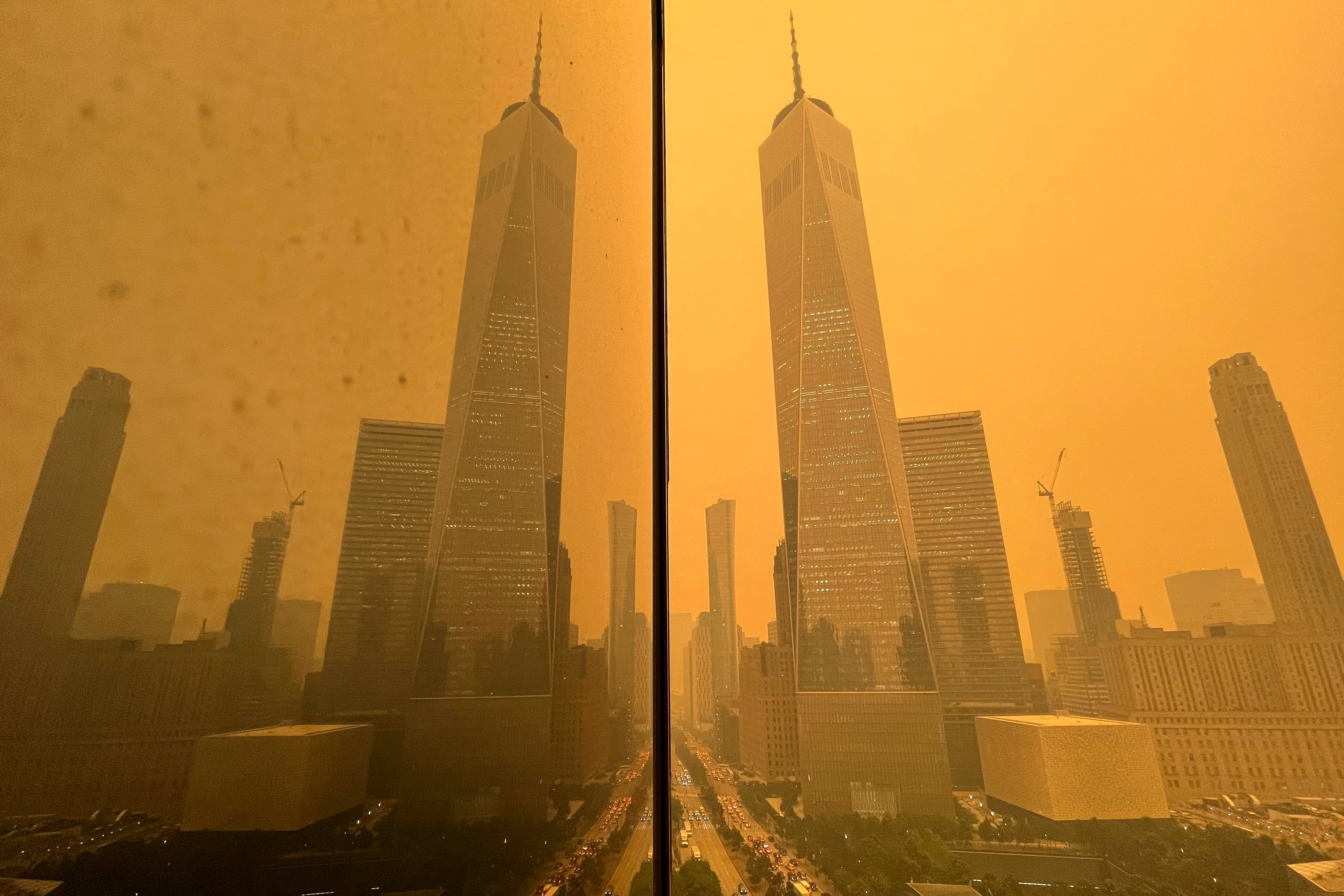 Traffic in New York moves along West Street past One World Trade Center amid a smokey haze caused by wildfires in Canada in june 2023