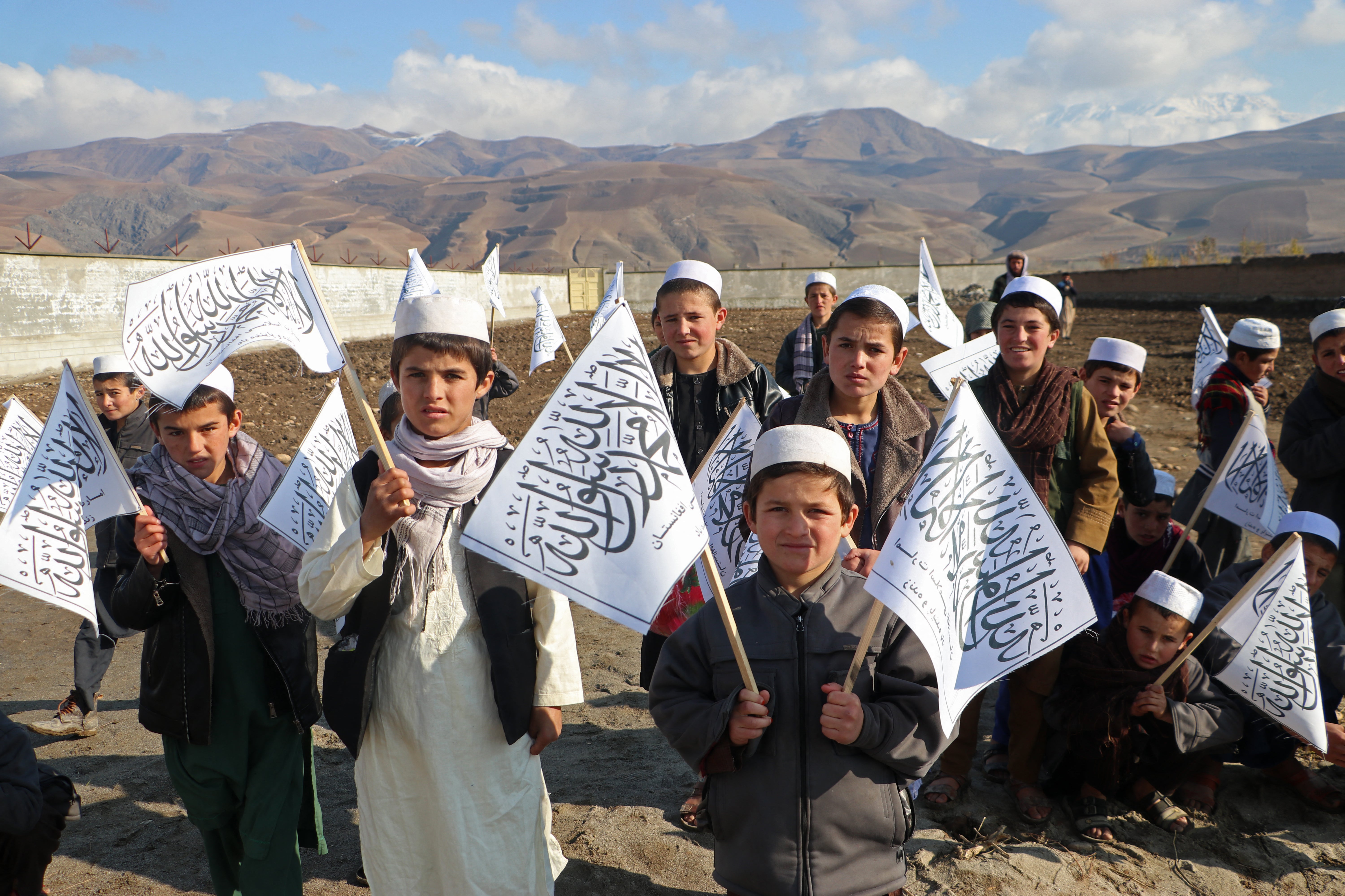 Afghan children from a Madrassa or an Islamic school hold Taliban’s flag in Fayzabad district of Badakhshan