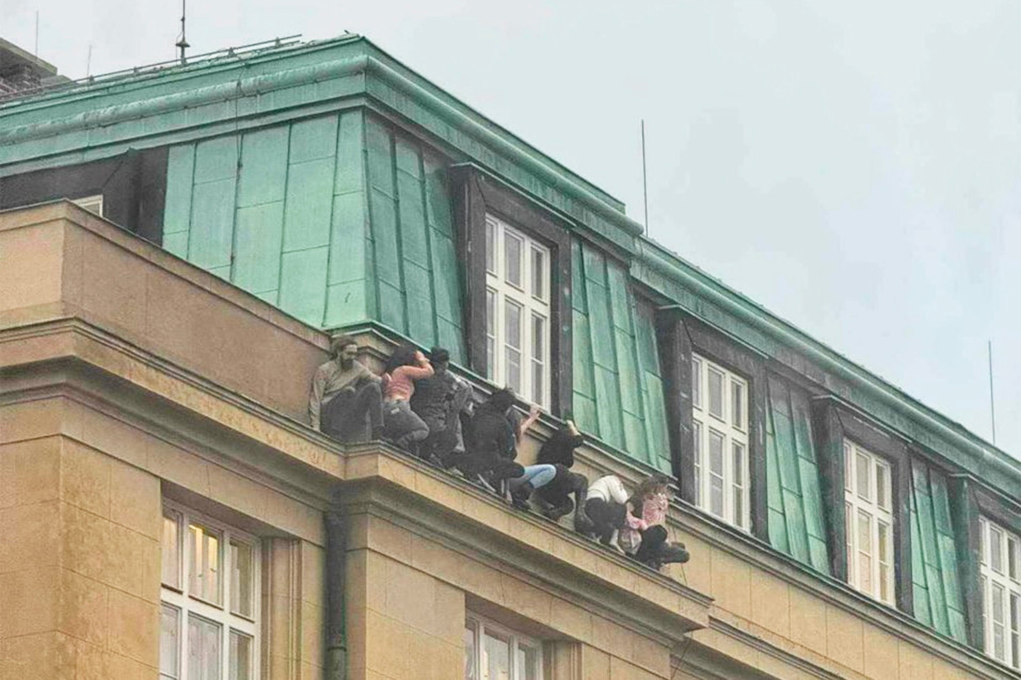 Eight students seen hiding on a building ledge to escape the gunman