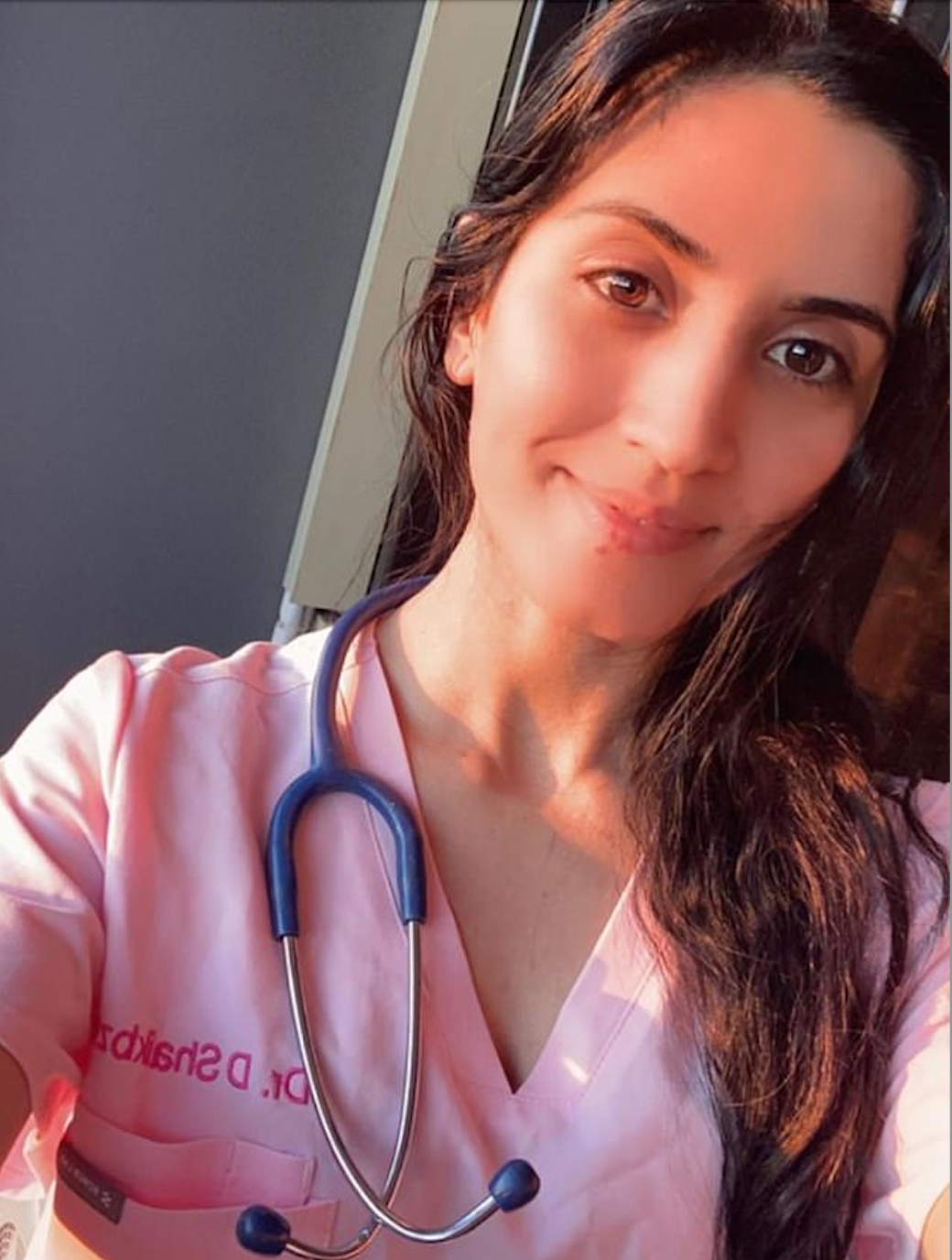 ‘Dr’ Karezi poses in pink scrubs and a stethoscope on Instagram