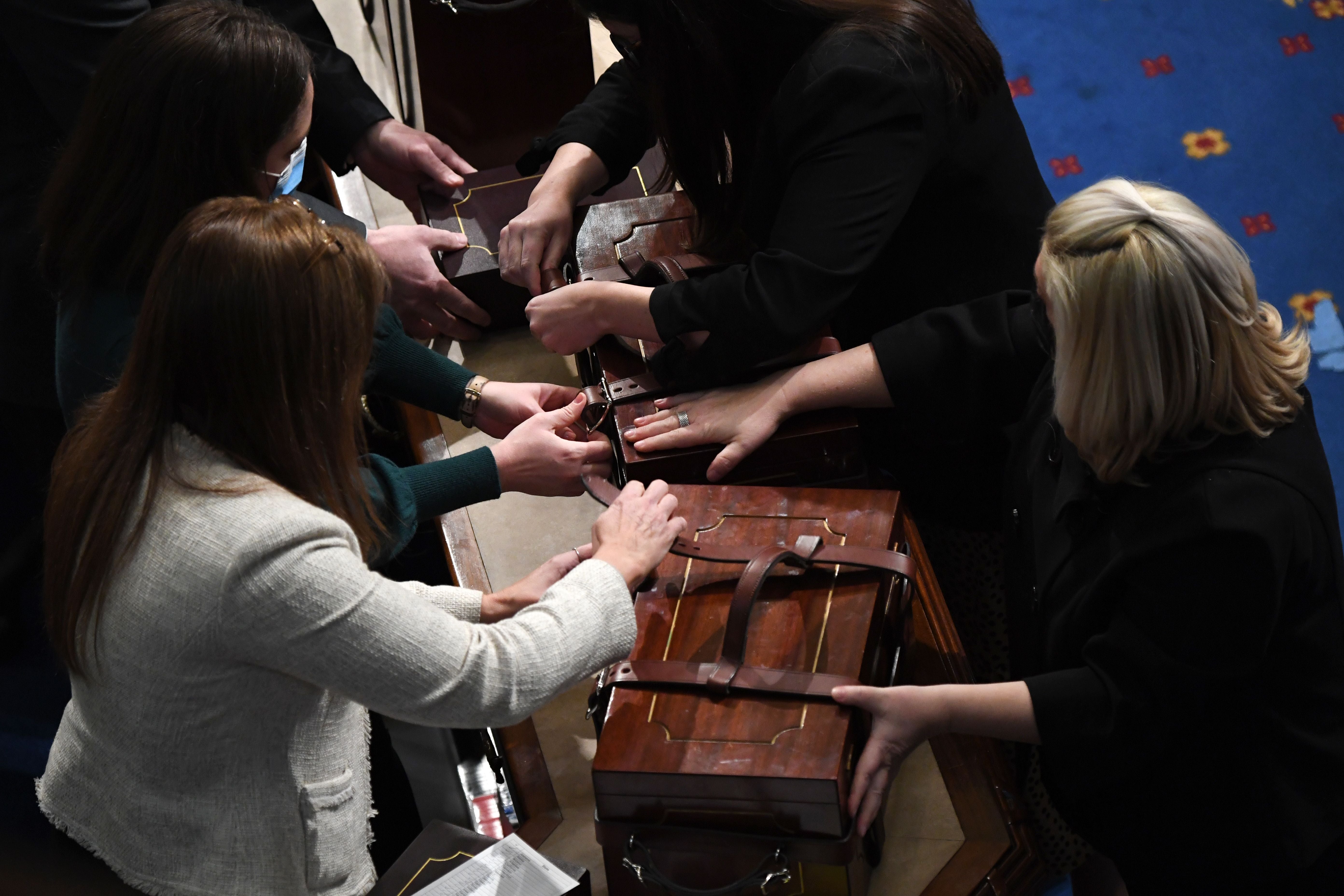 Cases containing electoral votes are opened during a joint session of Congress after the session resumed following protests at the US Capitol in Washington, DC, early on 7 January 2021