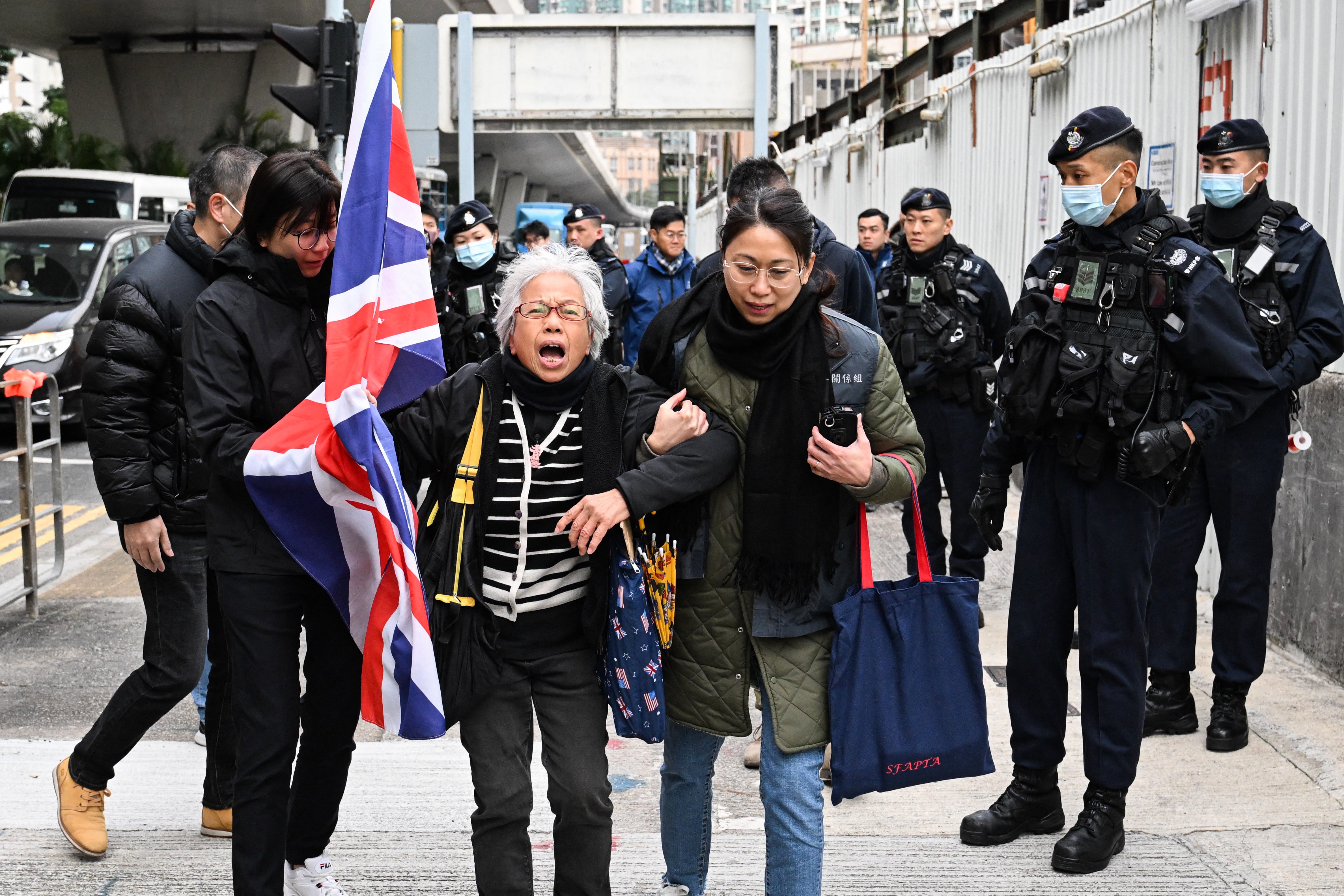 Police stop activist Alexandra Wong, centre, also known as Grandma Wong, as she carries a union jack outside court