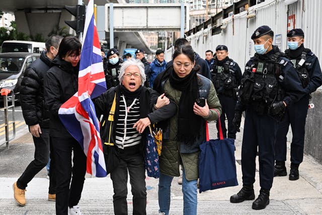<p>Policemen stop activist Alexandra Wong, also known as Grandma Wong, as she carries a union flag outside the West Kowloon court ahead of the trial of pro-democracy media tycoon Jimmy Lai on Friday</p>