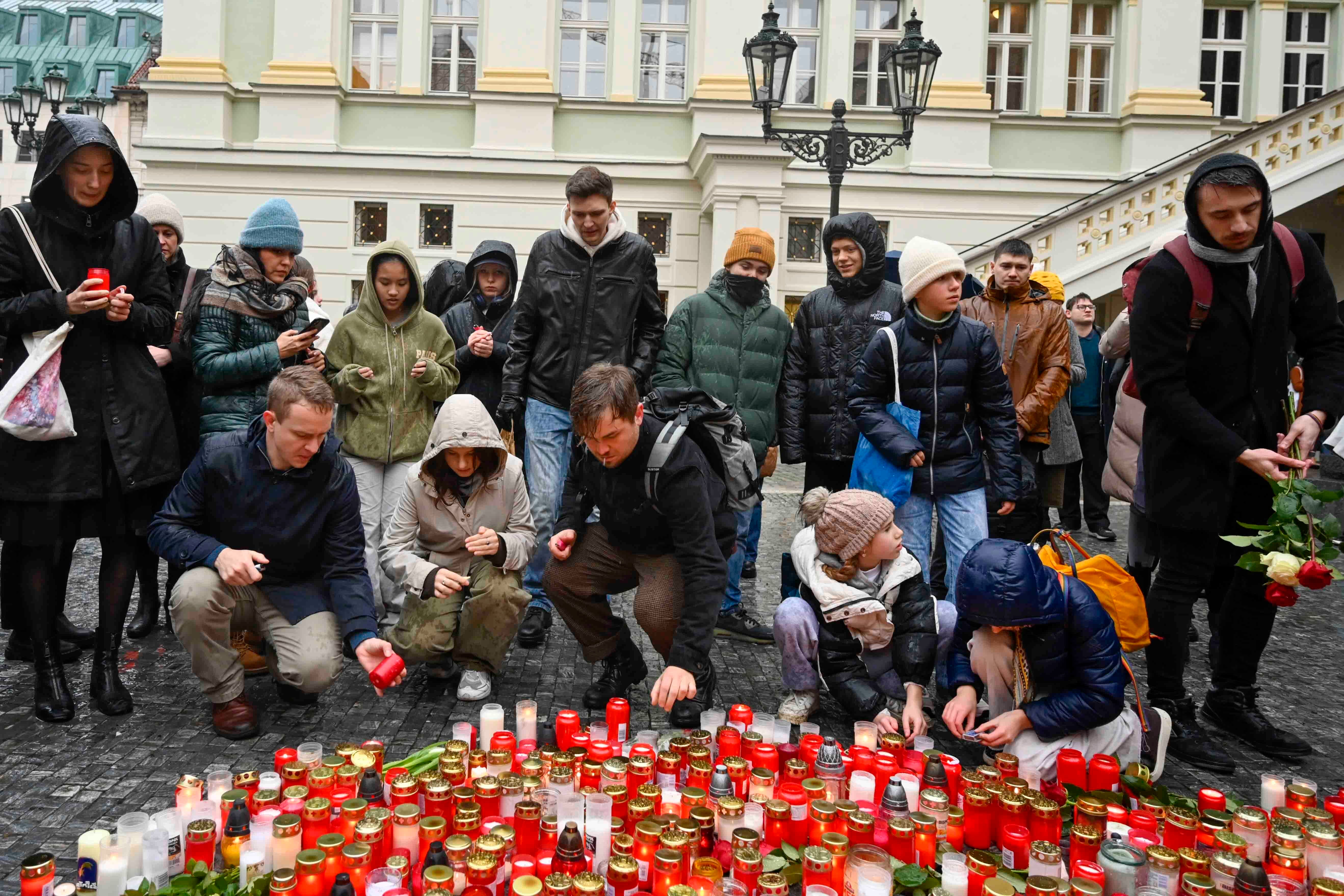 Mourners lay candles outside the Charles University building where yesterday’s attack took place